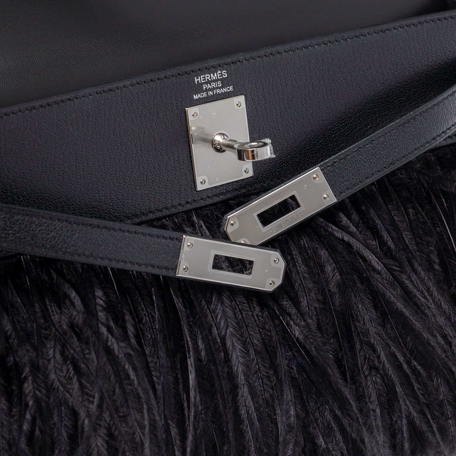 Close-up of palladium hardware and black leather strap on Hermès Kelly Elan Black Chevre Chamkila and Ostrich Feather Palladium Hardware