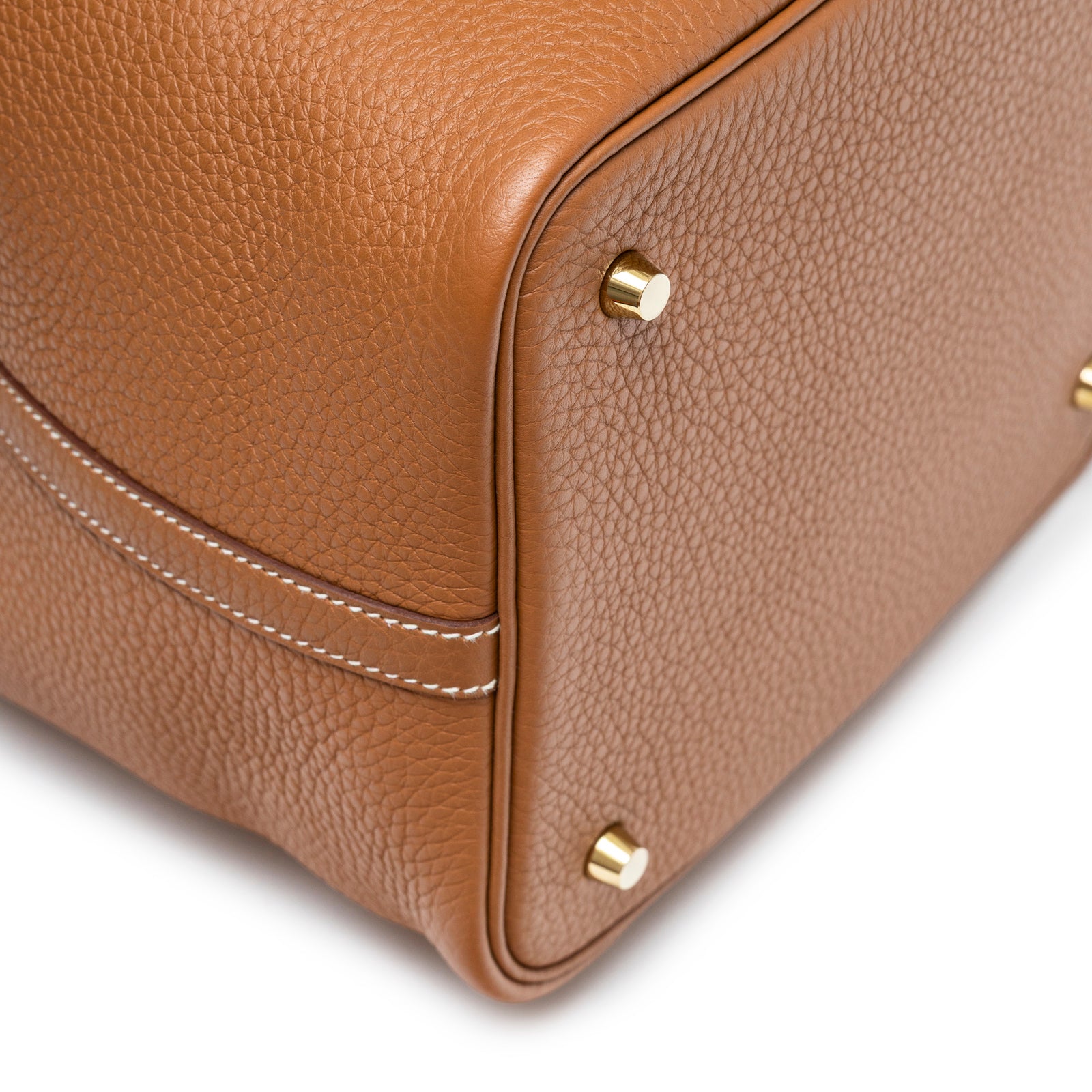 Close-up of the bottom corner of Hermès Picotin 22 Gold Clemence Gold Hardware showing leather texture and gold feet