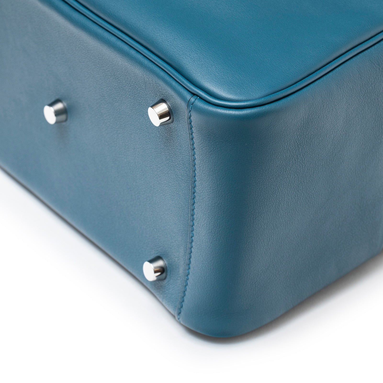 Close-up of bottom corner and palladium feet on Hermès Lindy 26 Colvert Swift Palladium Hardware showing smooth leather grain