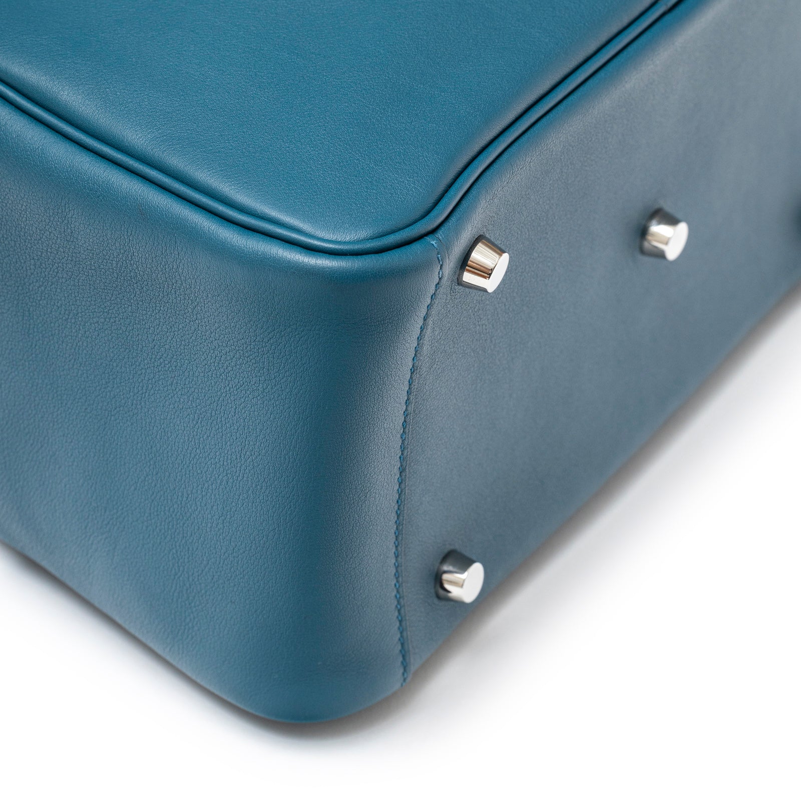 Close-up of Hermès Lindy 26 Colvert Swift Palladium Hardware bottom corner showing smooth leather and metal feet
