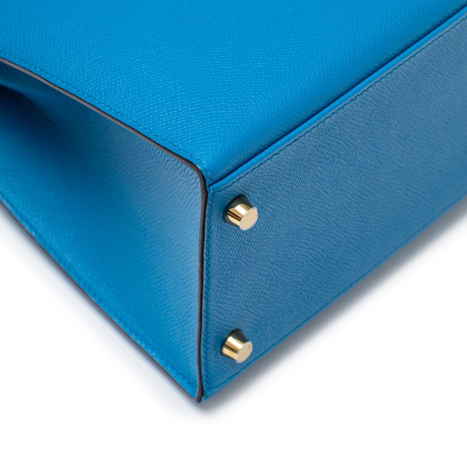 Close-up of bottom corner and gold hardware feet on Hermès Kelly Sellier 28 Blue Zanzibar Epsom Gold Hardware bag