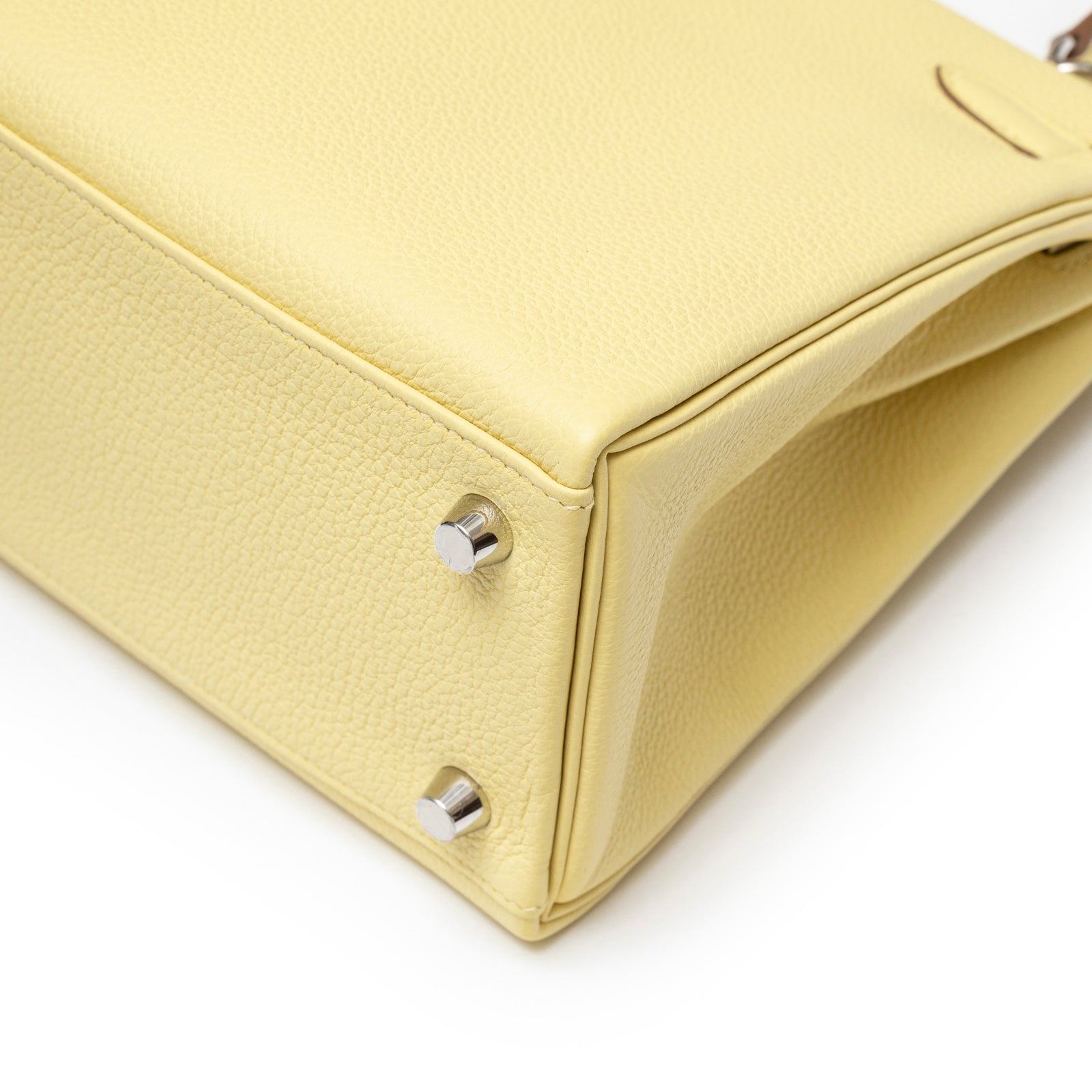 Close-up of bottom corner with palladium feet on Hermès Kelly 25 Retourne Togo Jaune Poussin bag