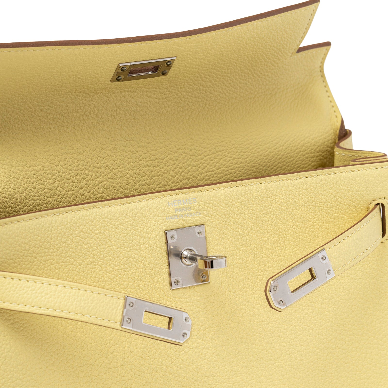 Close-up interior view of Hermès Kelly 25 Retourne Togo Jaune Poussin Palladium Hardware showing clasp and textured leather