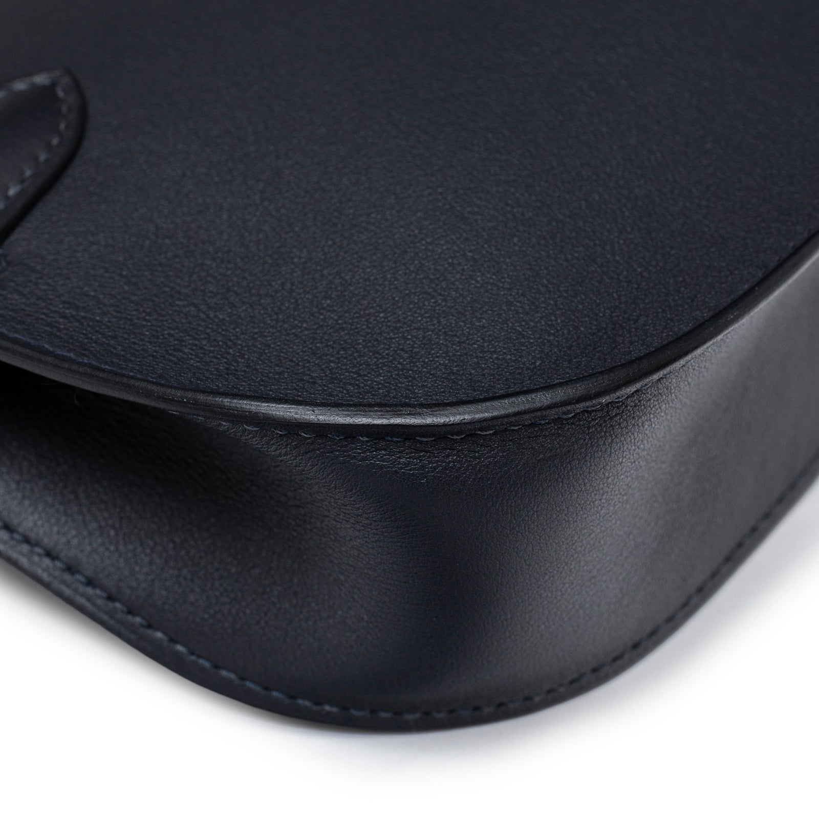 Close-up of bottom corner showing smooth black leather on Hermès Mini Jypsiere Caban Swift Palladium Hardware bag