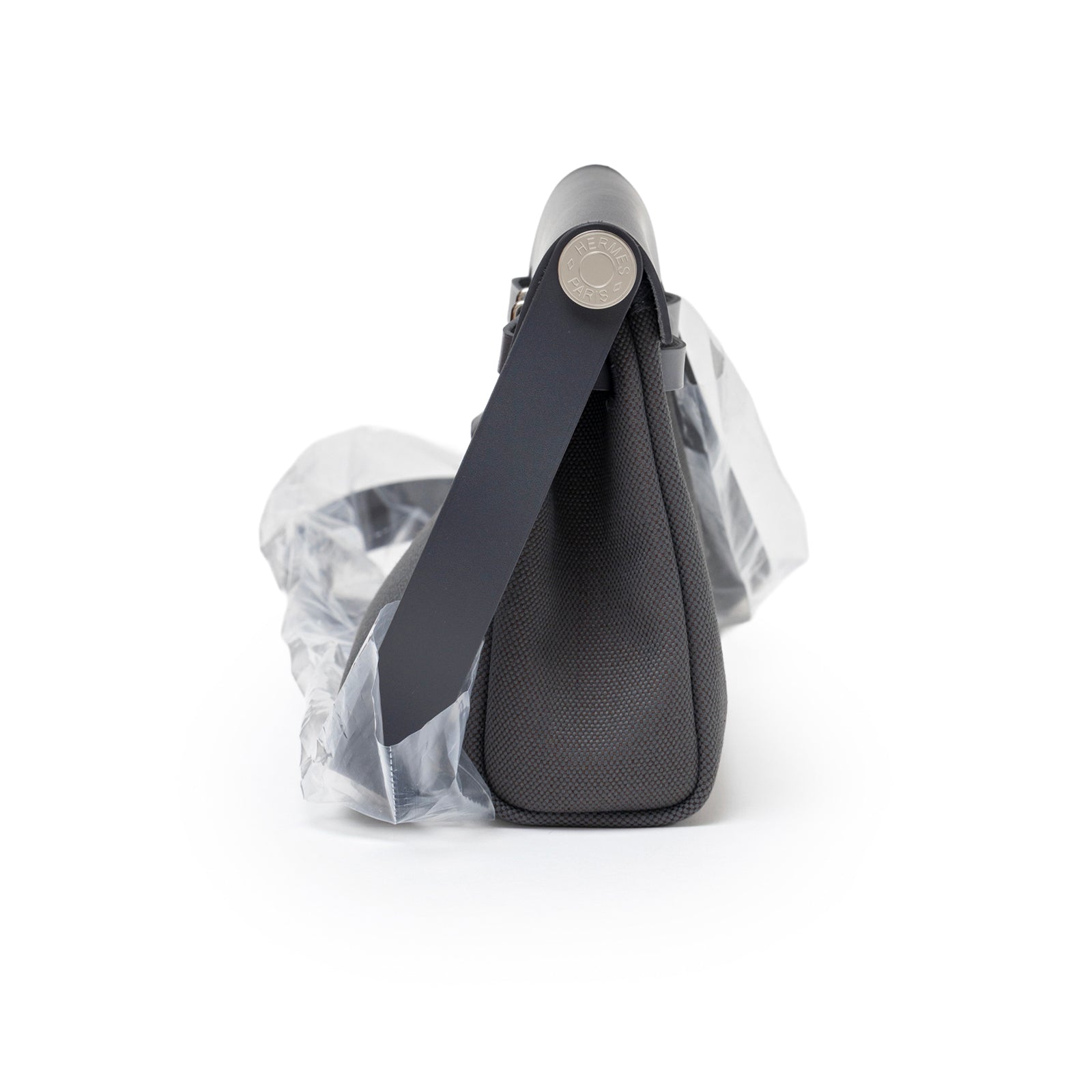 Side view of Hermès Mini Herbag Zip 20 Ardoise Toile and Vache Hunter Palladium Hardware showing textured canvas and strap detail