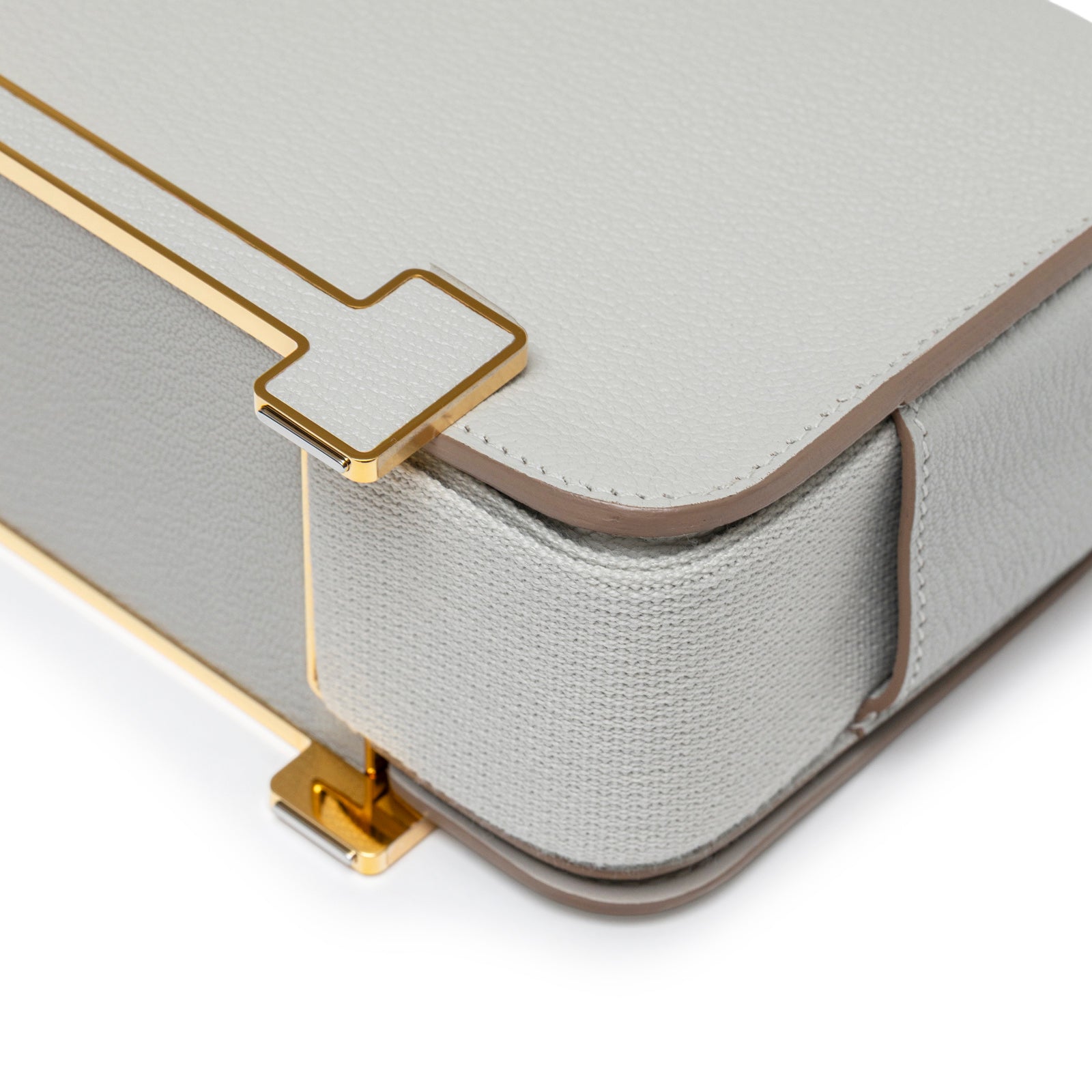 Close-up of gold hardware and textured leather corner on Hermès Geta Gris Perle Chevre Mysore Gold Hardware bag