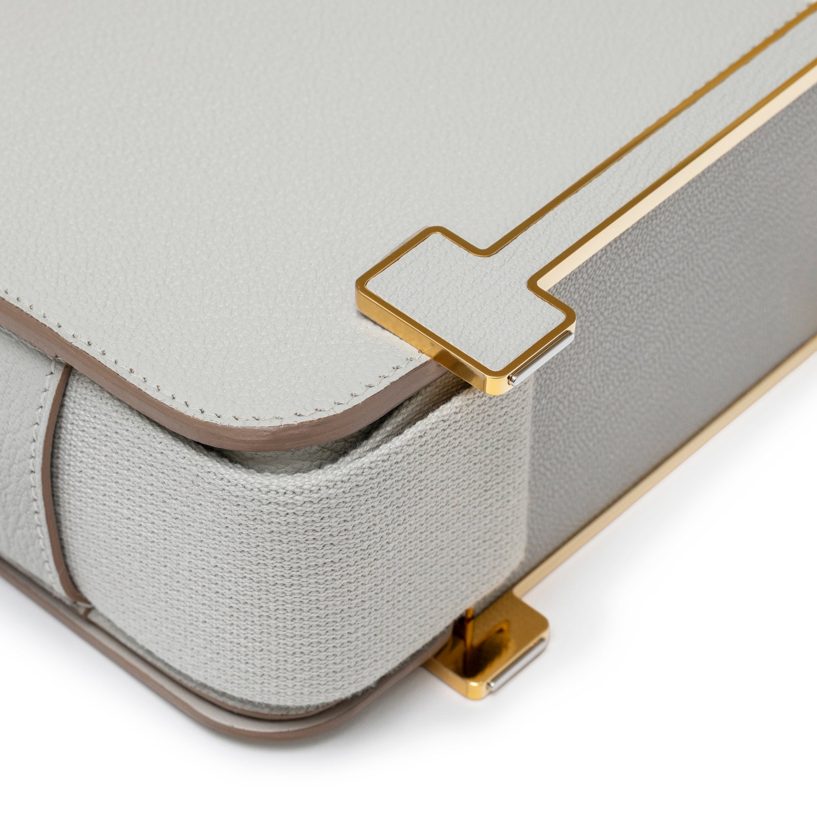 Close-up angled shot of Hermès Geta Gris Perle Chevre Mysore Gold Hardware highlighting leather and gold corner detail