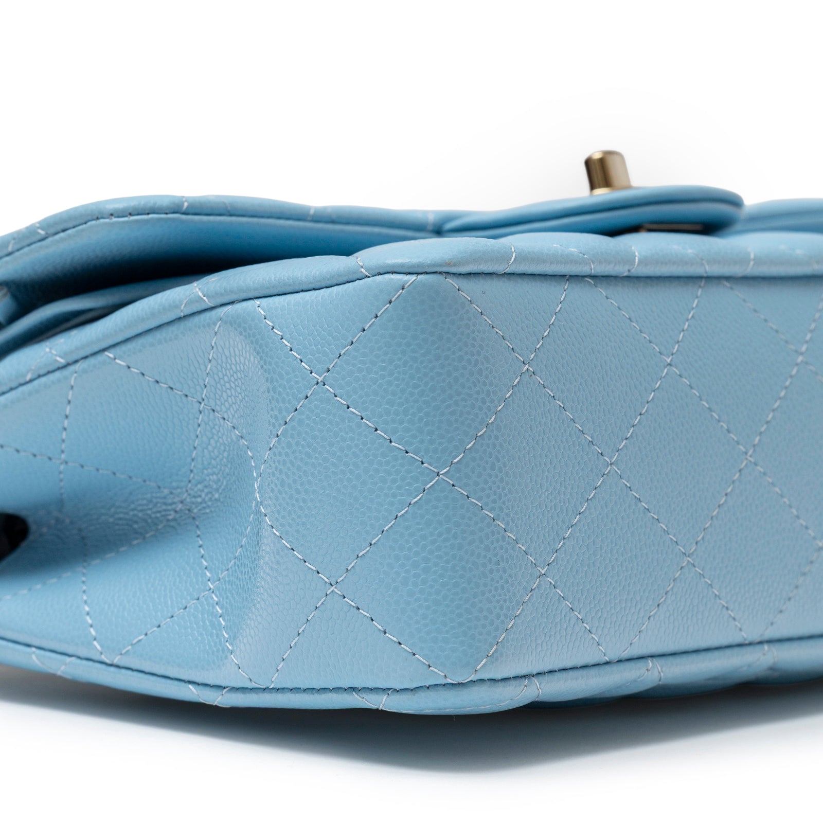 Close-up side view of Chanel Small Classic Flap Bag Blue Caviar Light Gold Hardware showing quilted leather texture