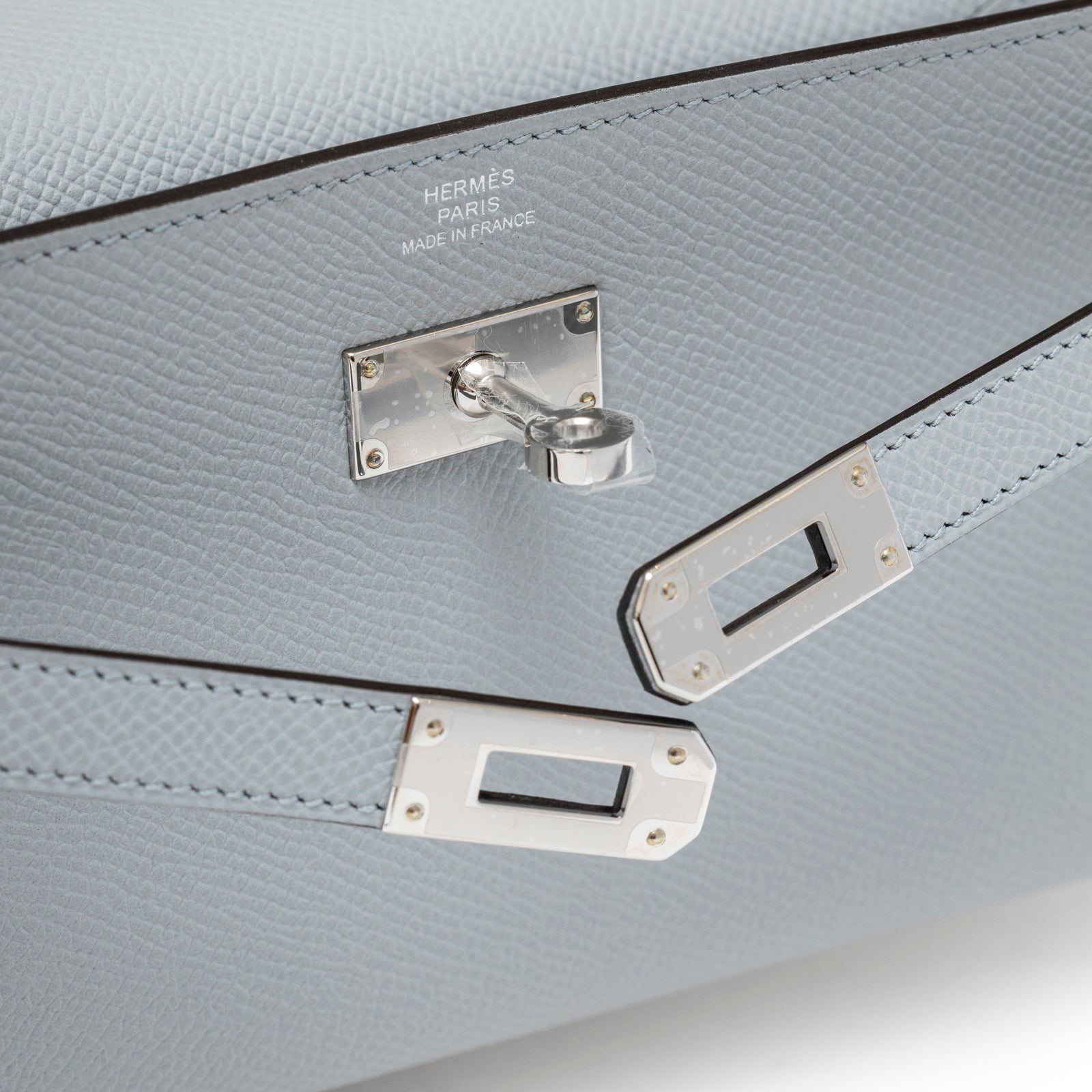 Close-up of Hermès Kelly To Go Wallet Blue Glacier Epsom Palladium Hardware showing clasp and leather texture