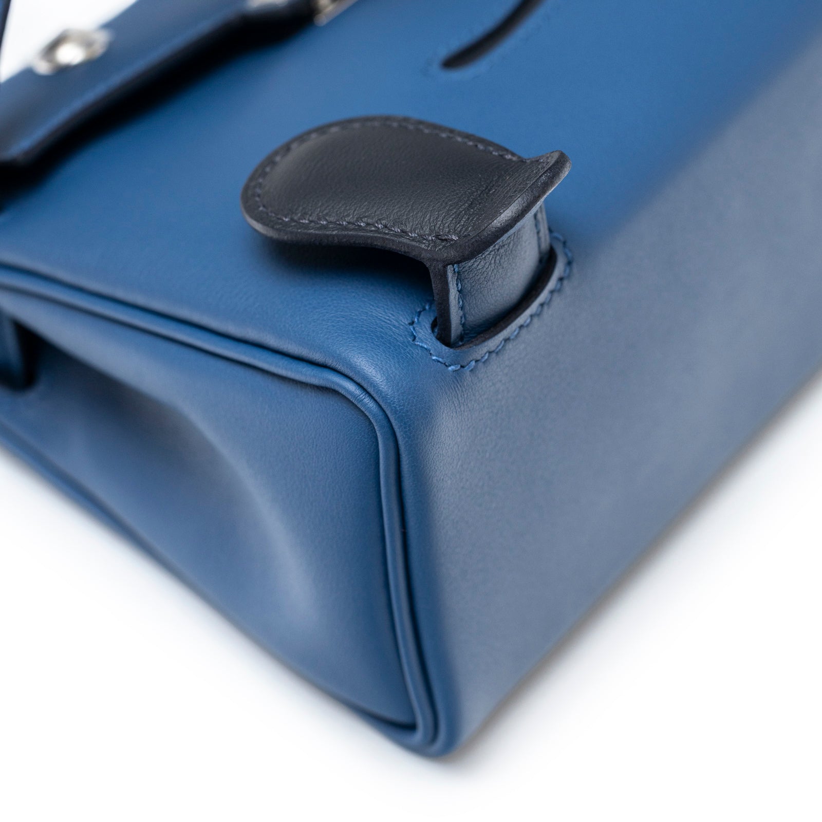 Close-up of corner stitching and leather tab on Hermès Quelle Idolle Kelly Doll Bleu Tie and Caban Swift Palladium Hardware