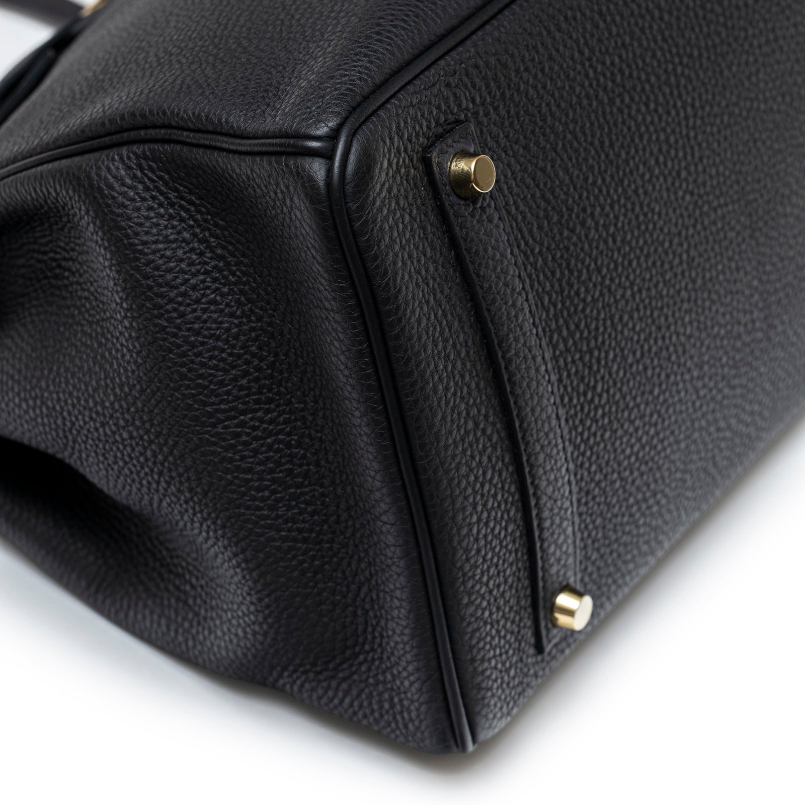Close-up of bottom corner on Hermès Birkin 35 Black Togo Gold Hardware showing textured leather and gold feet detail