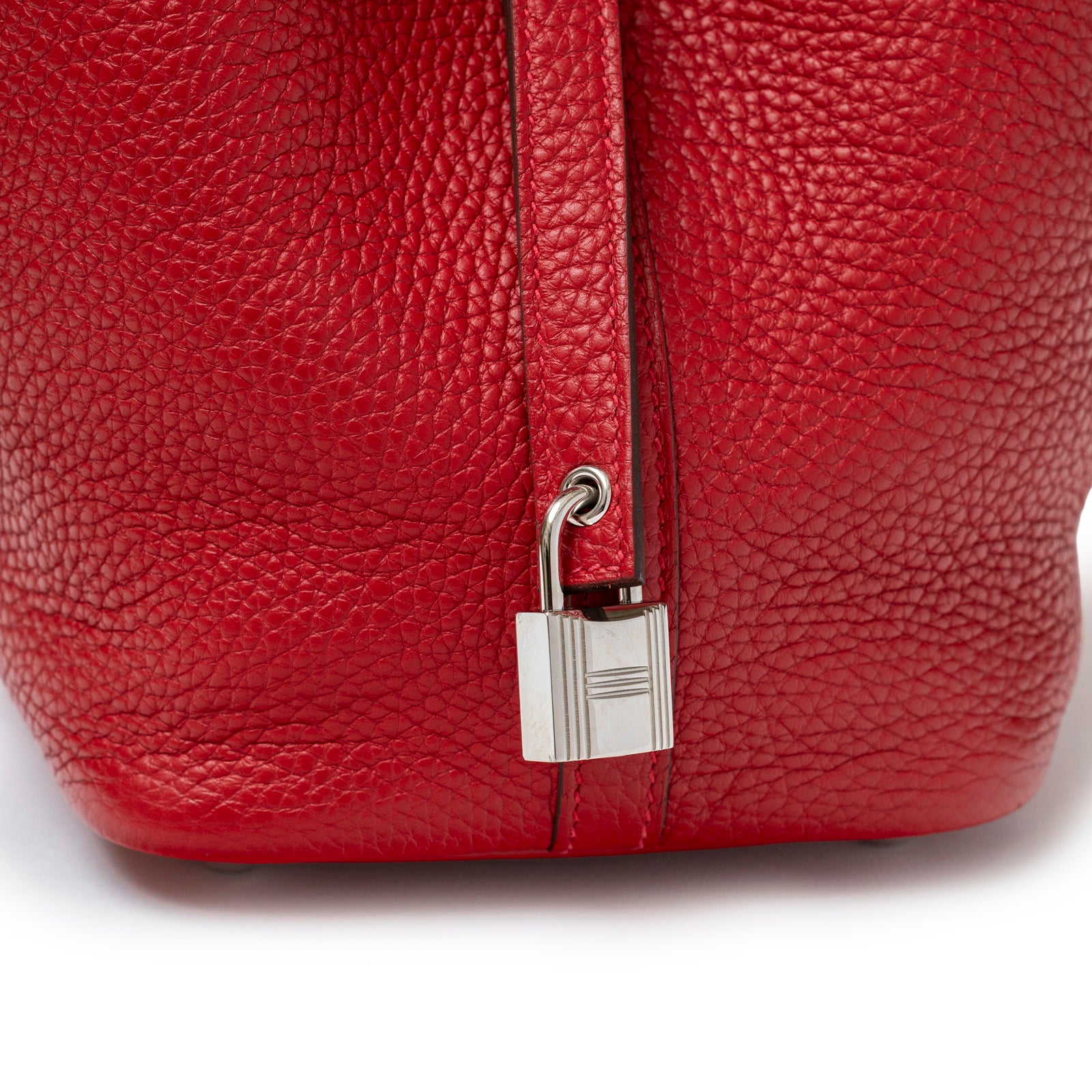 Close-up of bottom corner on Hermès Picotin 18 Rouge Casaque Clemence Palladium Hardware showing textured leather and padlock detail
