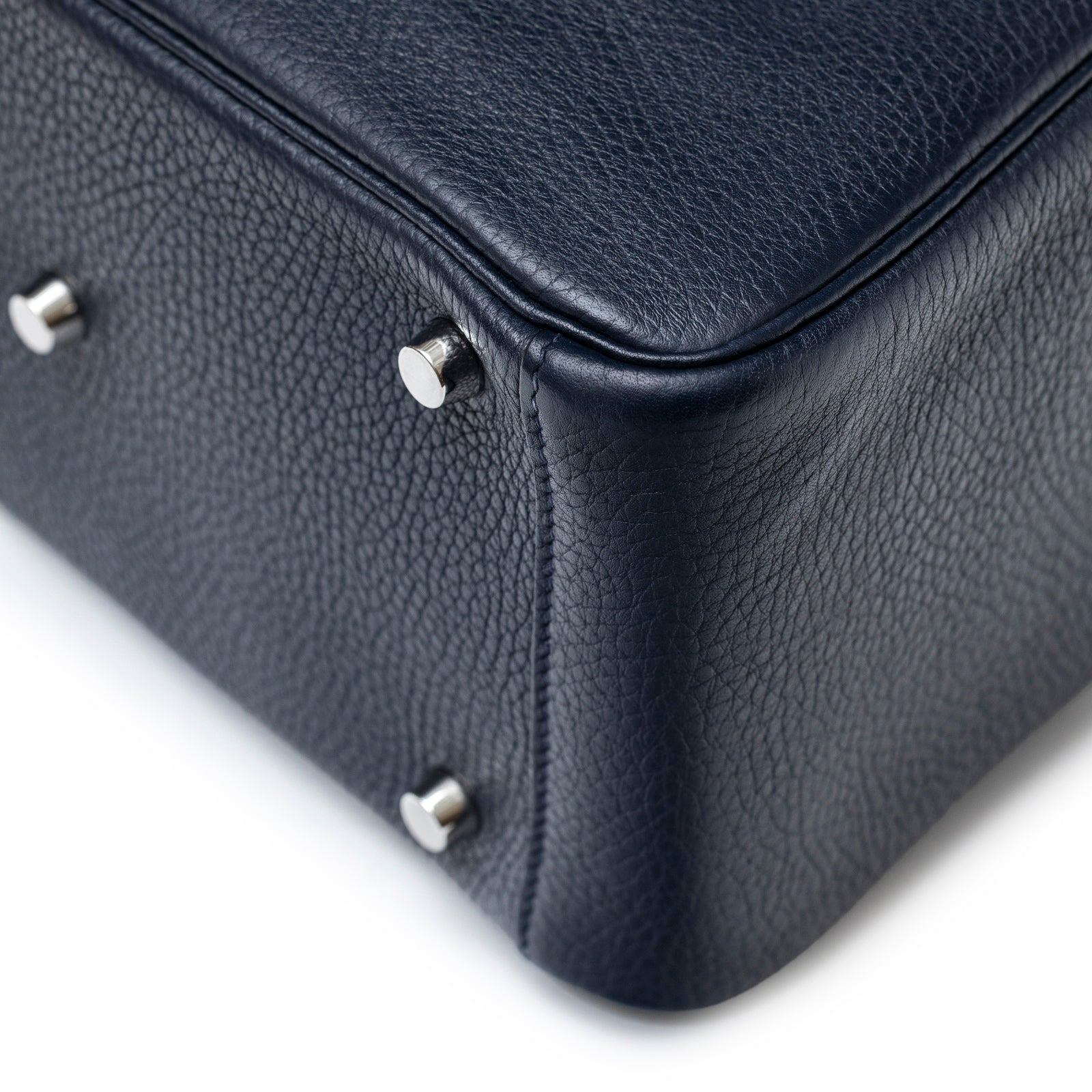 Close-up of bottom corner and palladium feet on Hermès Lindy 26 Blue Nuit Clemence Palladium Hardware bag