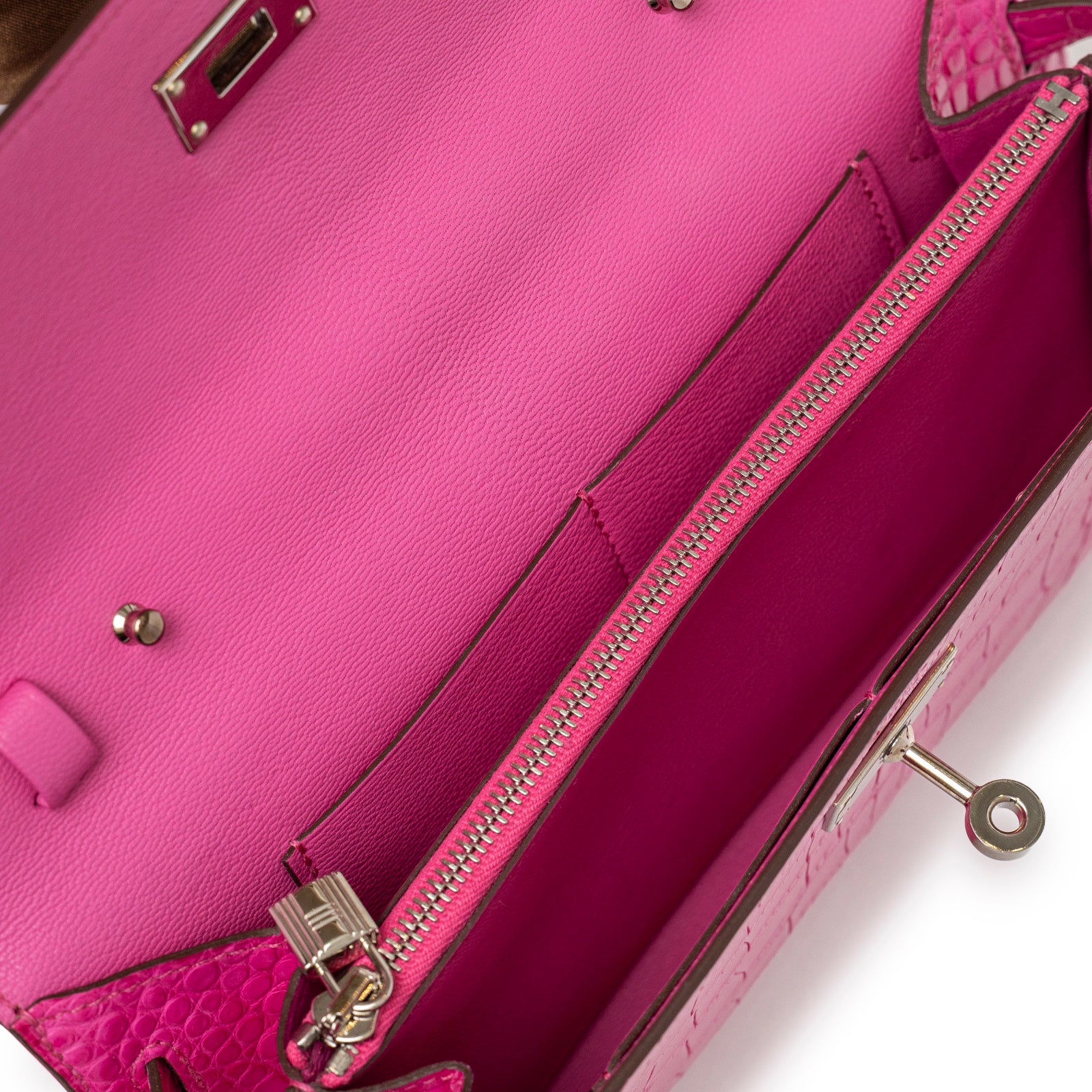 Close-up interior view of Hermès Kelly Wallet To Go Rose Shocking Matte Alligator Palladium Hardware showing zippered compartment and smooth lining