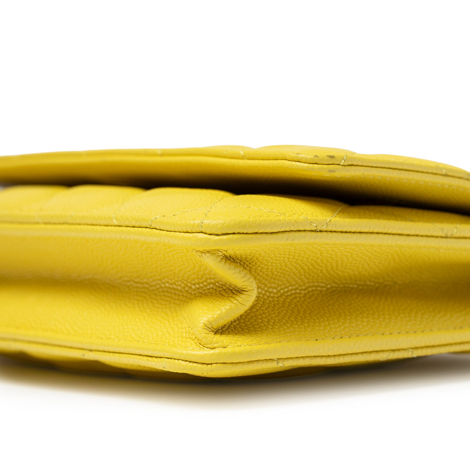 Close-up side view of corner cushion detail on Chanel Wallet On Chain Yellow Caviar Palladium Hardware