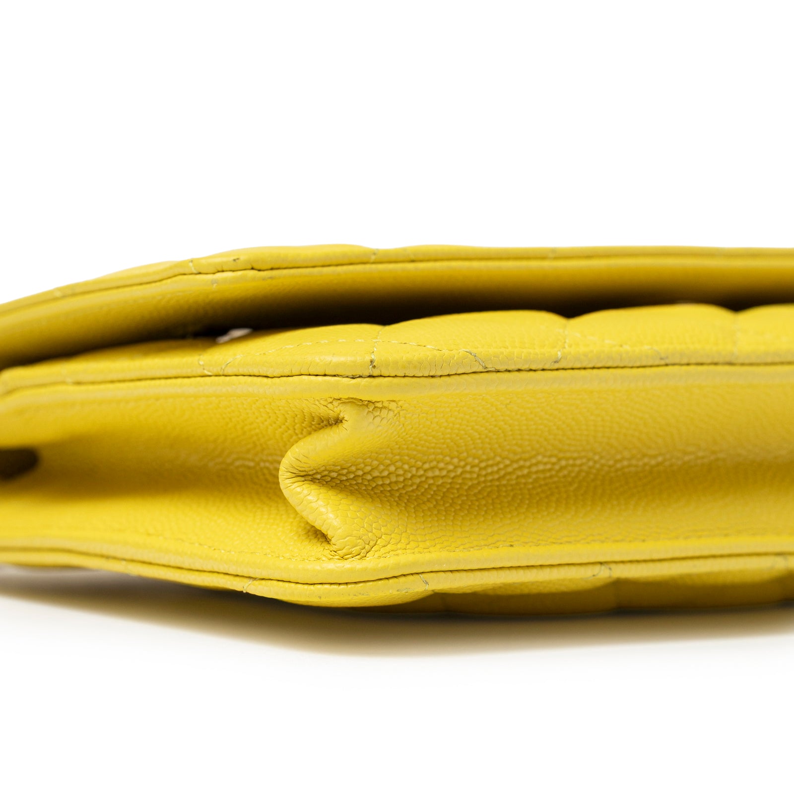 Close-up side view of Chanel Wallet On Chain Yellow Caviar Palladium Hardware showing textured leather edge and stitching detail