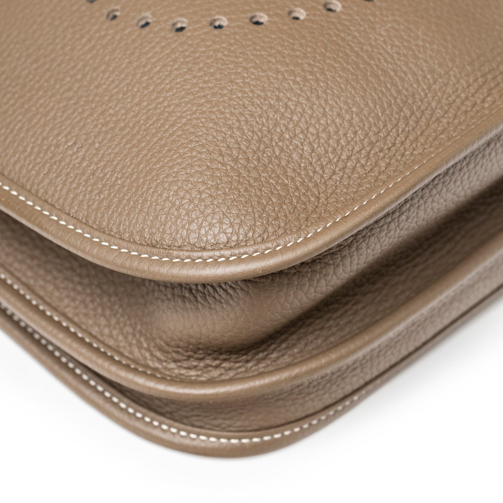 Close-up angled view of Hermès Evelyne PM 29 Etoupe Clemence Palladium Hardware leather texture and stitching detail