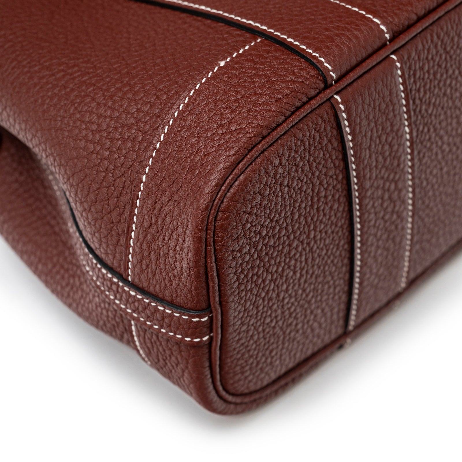 Close-up view of Hermès Mini Garden Party Neo 23 Rouge H Negonda Palladium Hardware corner and white stitching detail