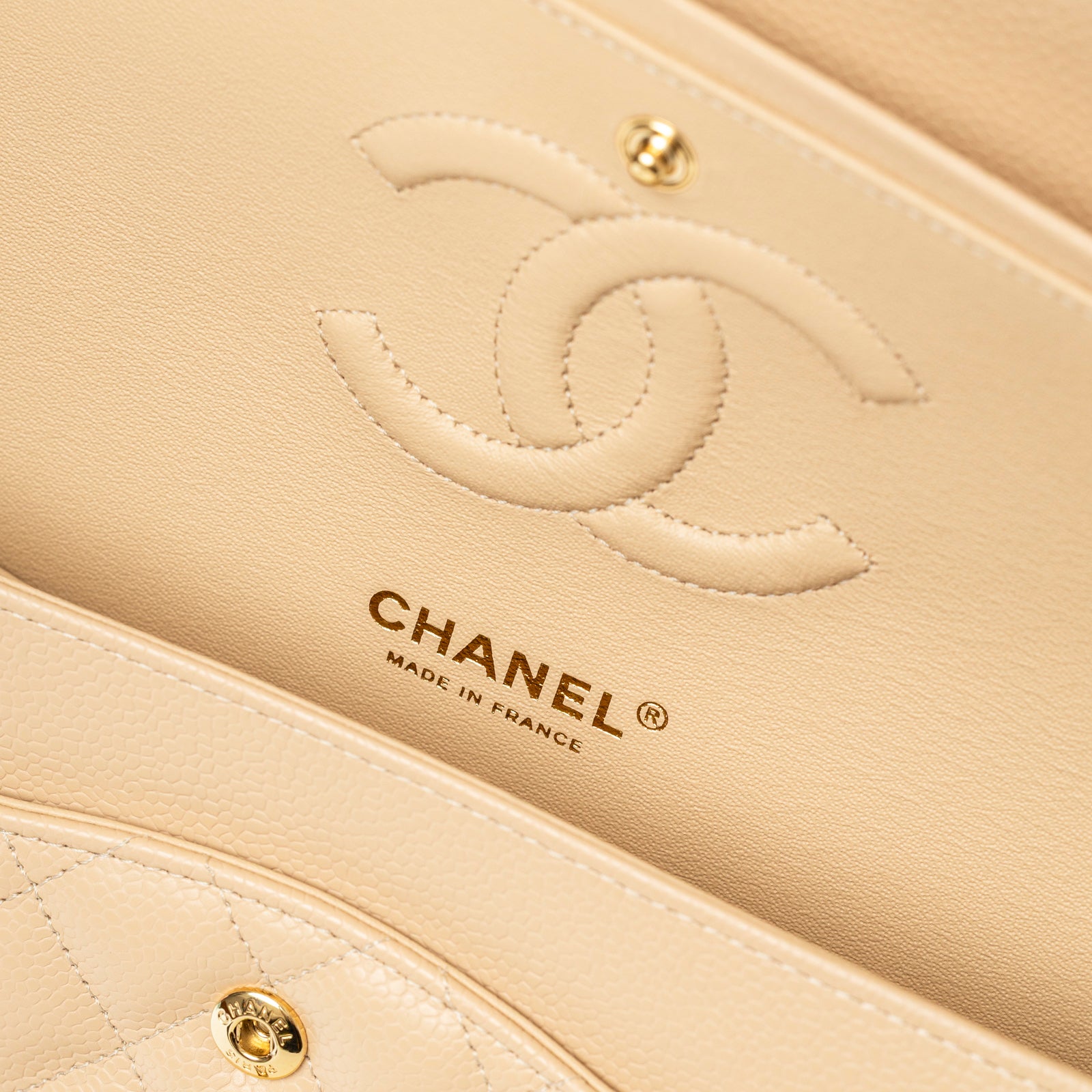 Close-up of interior flap showing Chanel Classic Flap Medium Caviar Beige Gold Hardware logo and stitching detail