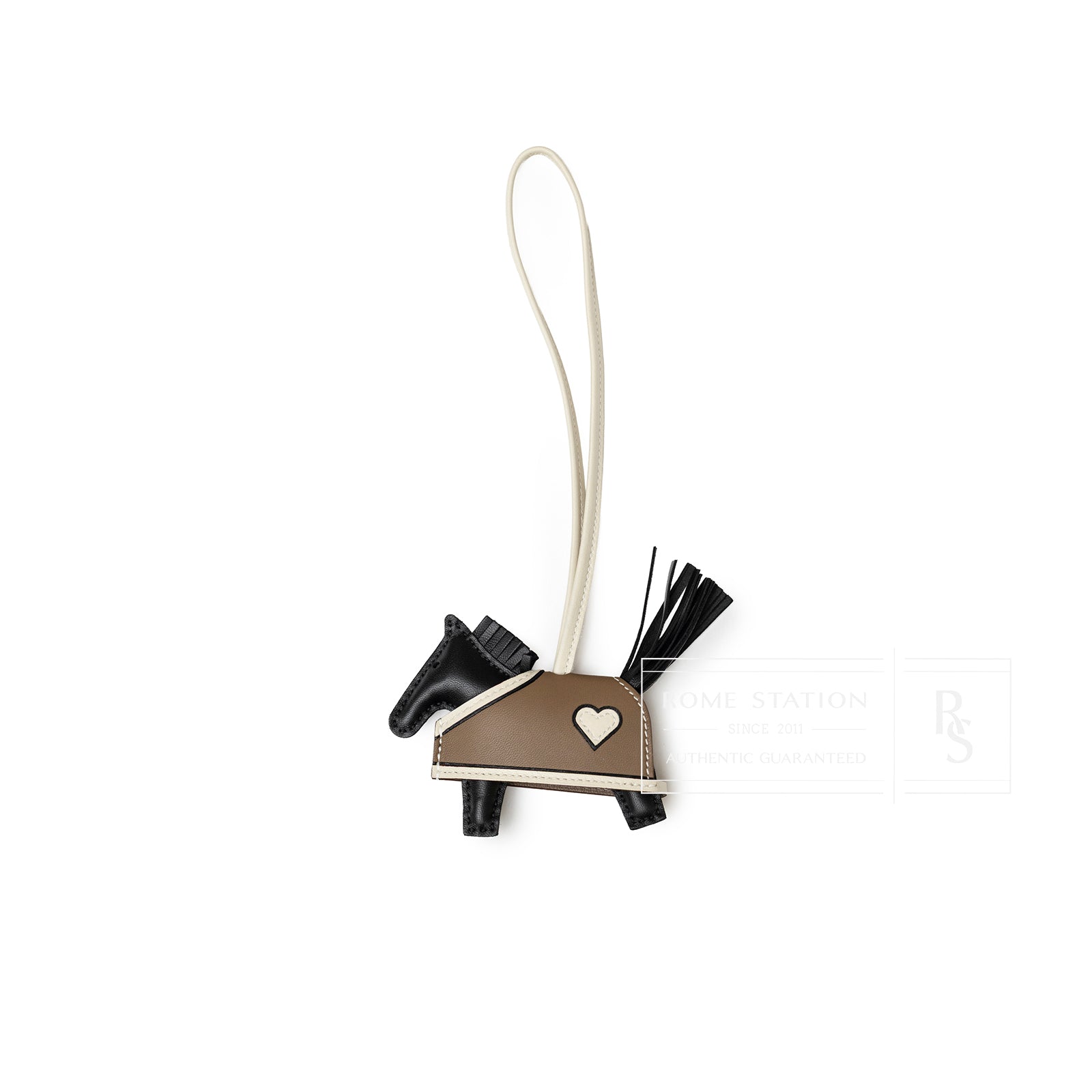 Top-down view of Hermès Rodeo Robeo Coeur Charm PM Etoupe Black Craie Milo Lambskin with heart detail and tassel tail