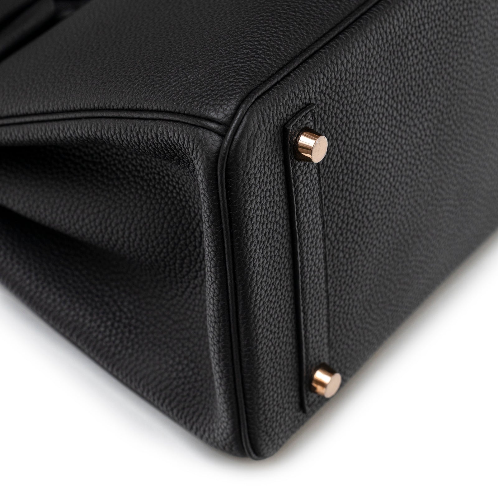 Close-up angled view of Hermès Birkin 30 Black Togo Rose Gold Hardware bottom corner with feet detail