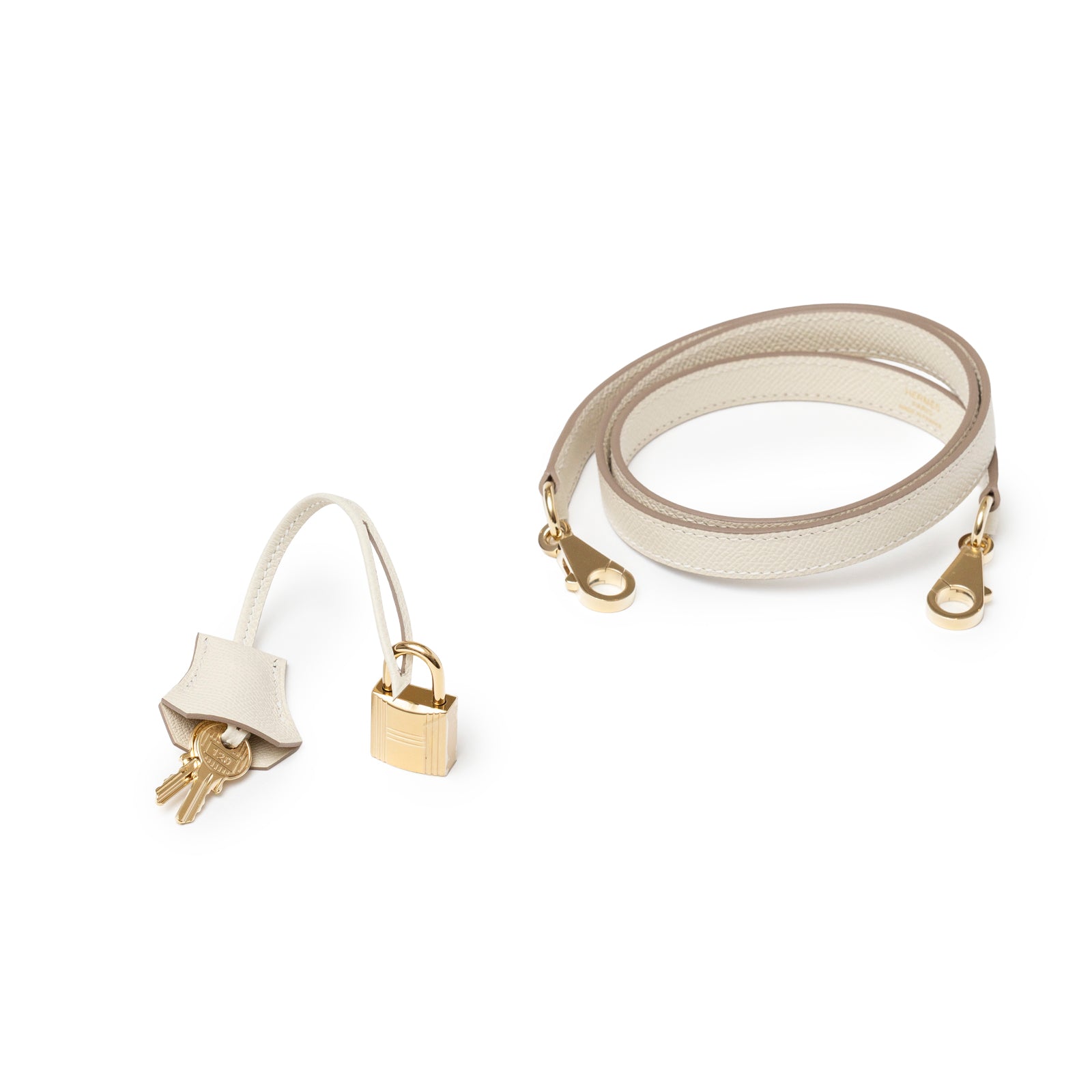 Hermès Kelly 25 Sellier Epsom Craie Permabrass Hardware detachable shoulder strap and lock set on white background