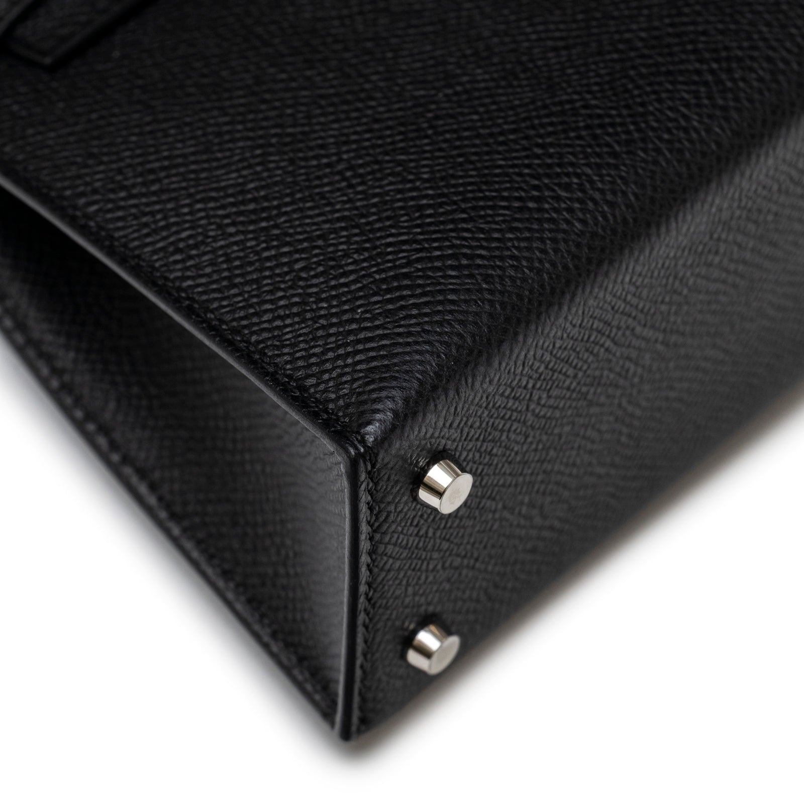 Close-up angled view of bottom corner showing Hermès Mini Kelly II Sellier Black Epsom Palladium Hardware feet and texture