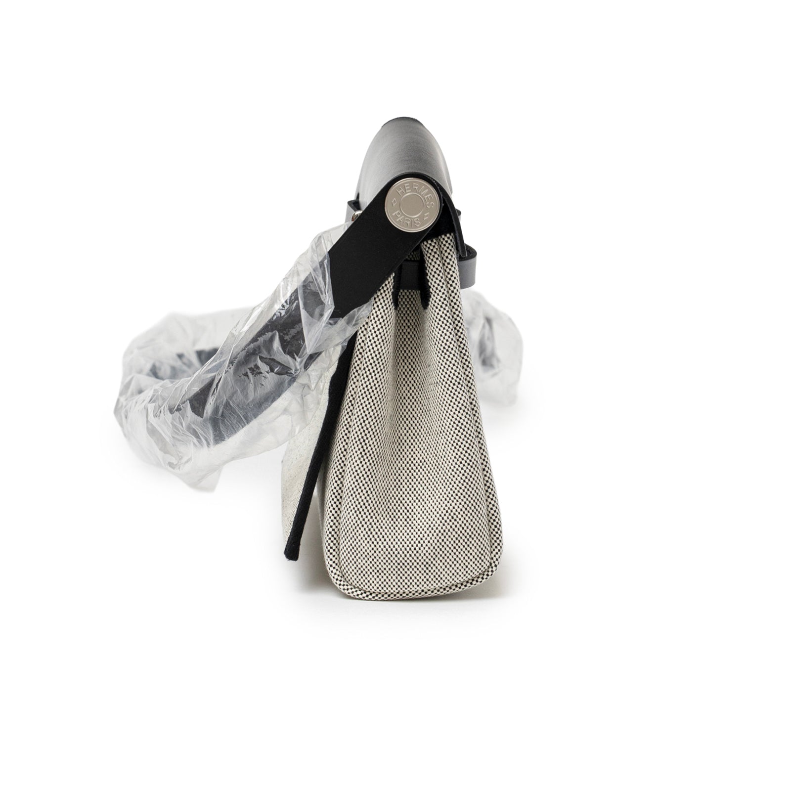 Side view of Hermès Mini Herbag Zip 20 Ecru/Black Toile and Vache Hunter Palladium Hardware with protected strap