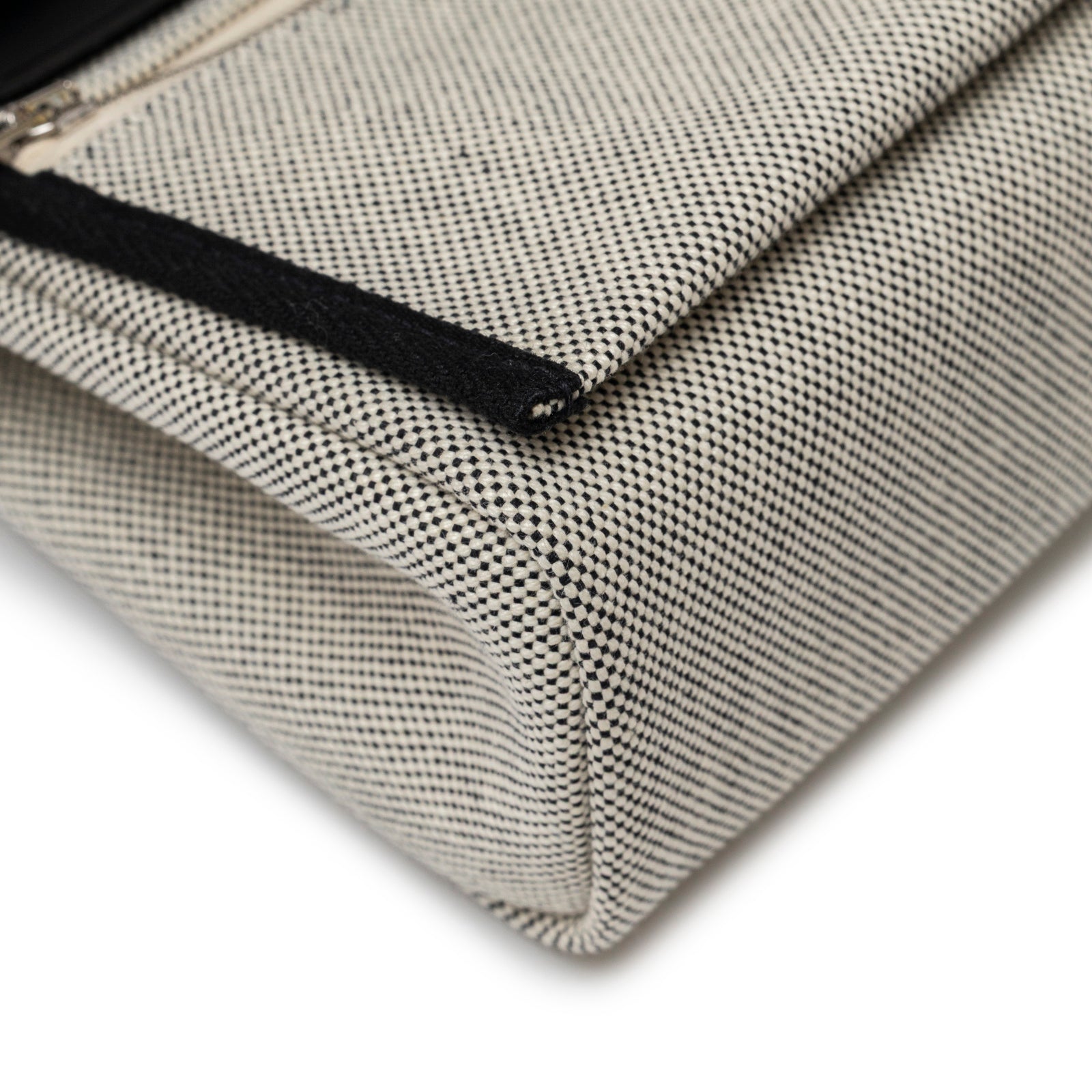 Close-up angled view of corner detail on Hermès Mini Herbag Zip 20 Ecru/Black Toile and Vache Hunter Palladium Hardware