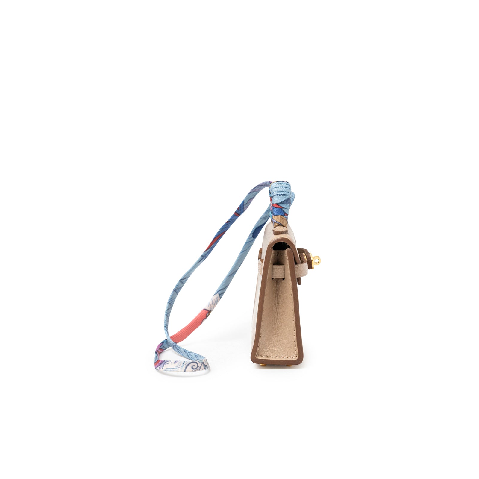 Side view of Hermès Mini Kelly Twilly Bag Charm Argile Tadelakt Gold Hardware with wrapped silk strap detail