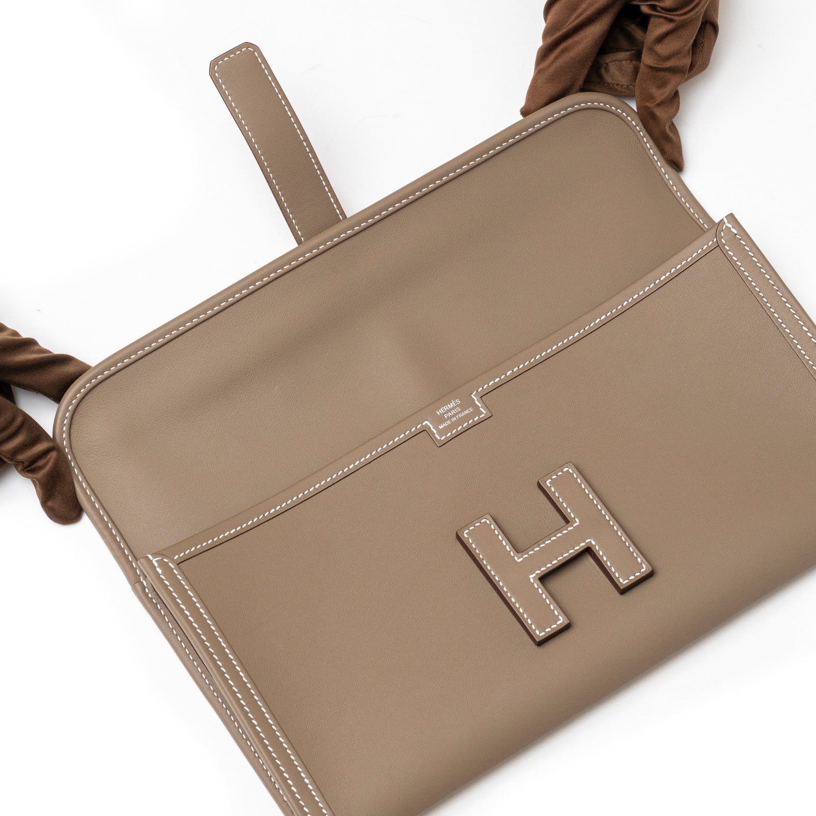 Top-down view of Hermès Jige Elan 29 Clutch Etoupe Swift showing flap open with visible logo and smooth leather interior