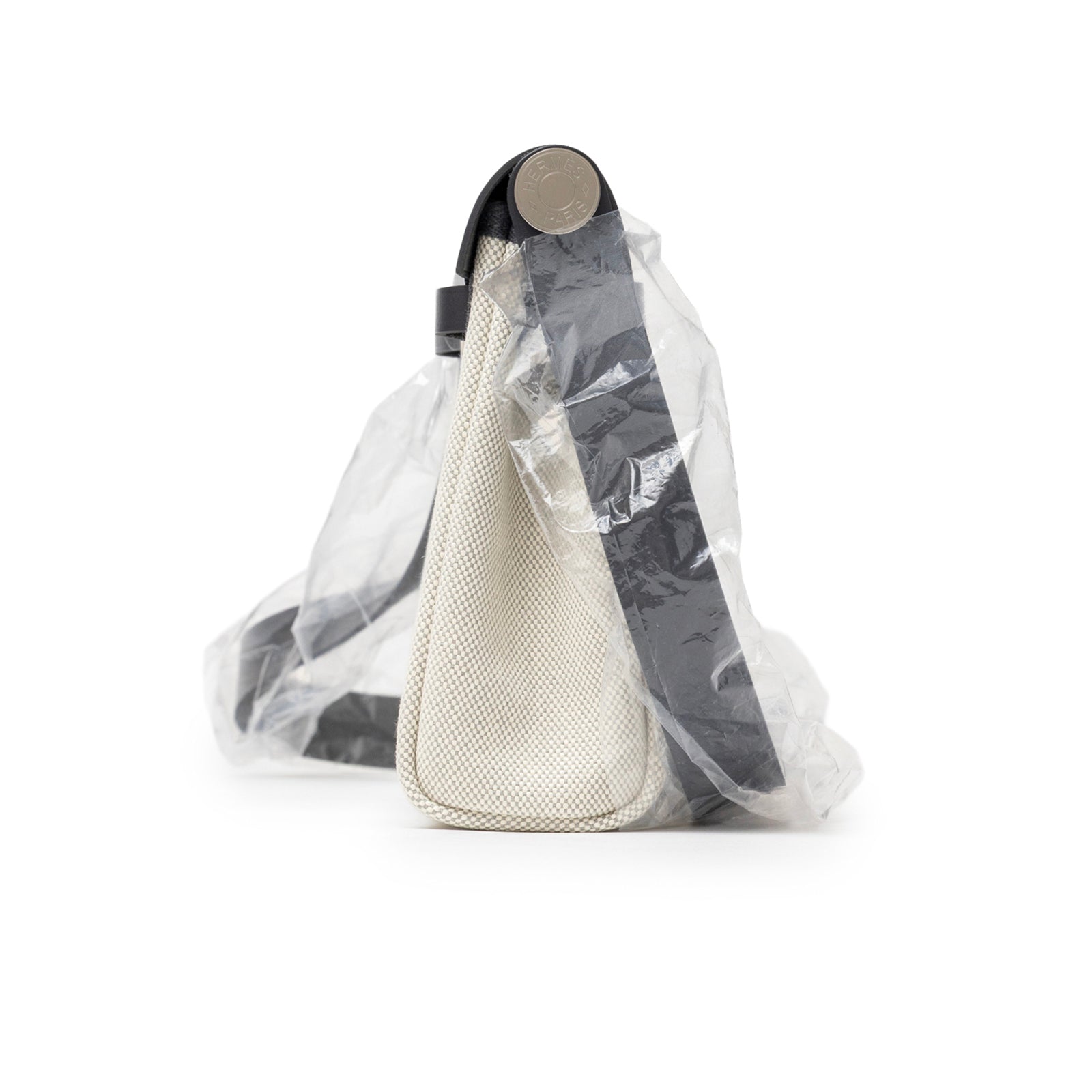 Side view of Hermès Mini Herbag Zip 20 Ecru-Blue Glacier/Ardoise Toile and Vache Hunter Palladium Hardware with strap wrapped in plastic