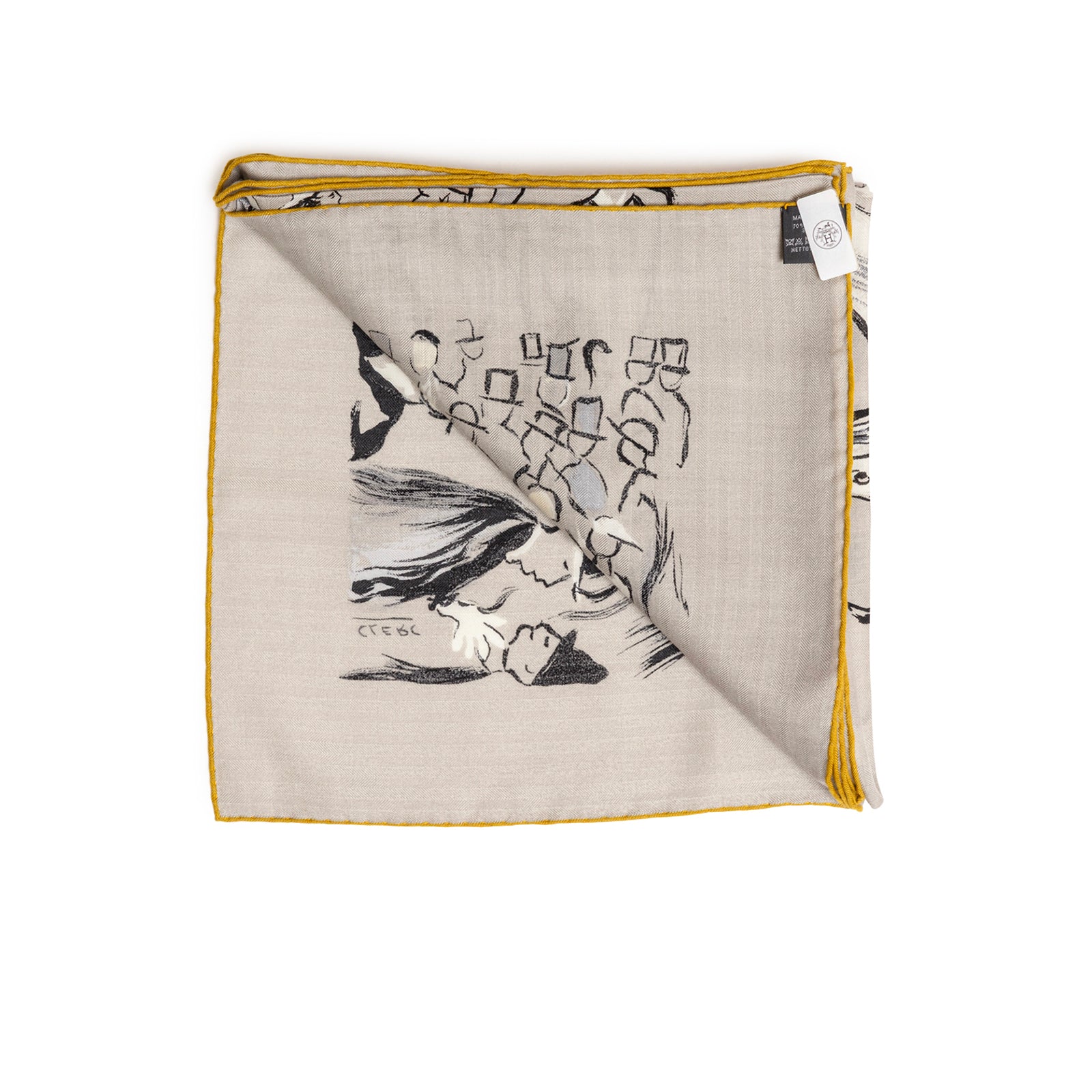 Top-down view of folded Hermès Paddock Shawl 140 Gris Etain/Blue Marine/Nacre with visible tag and brown trim