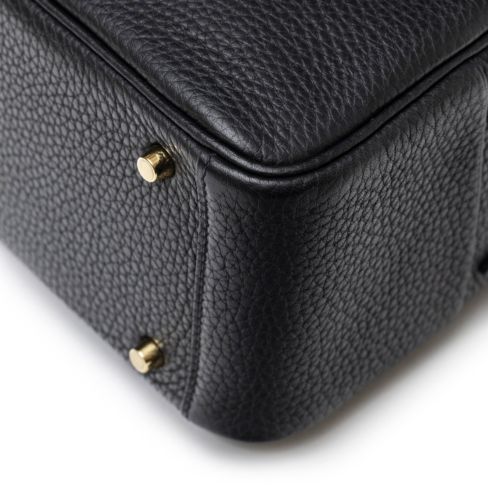 Close-up of Hermès Mini Lindy I Black Clemence Gold Hardware showing bottom corner and protective gold studs