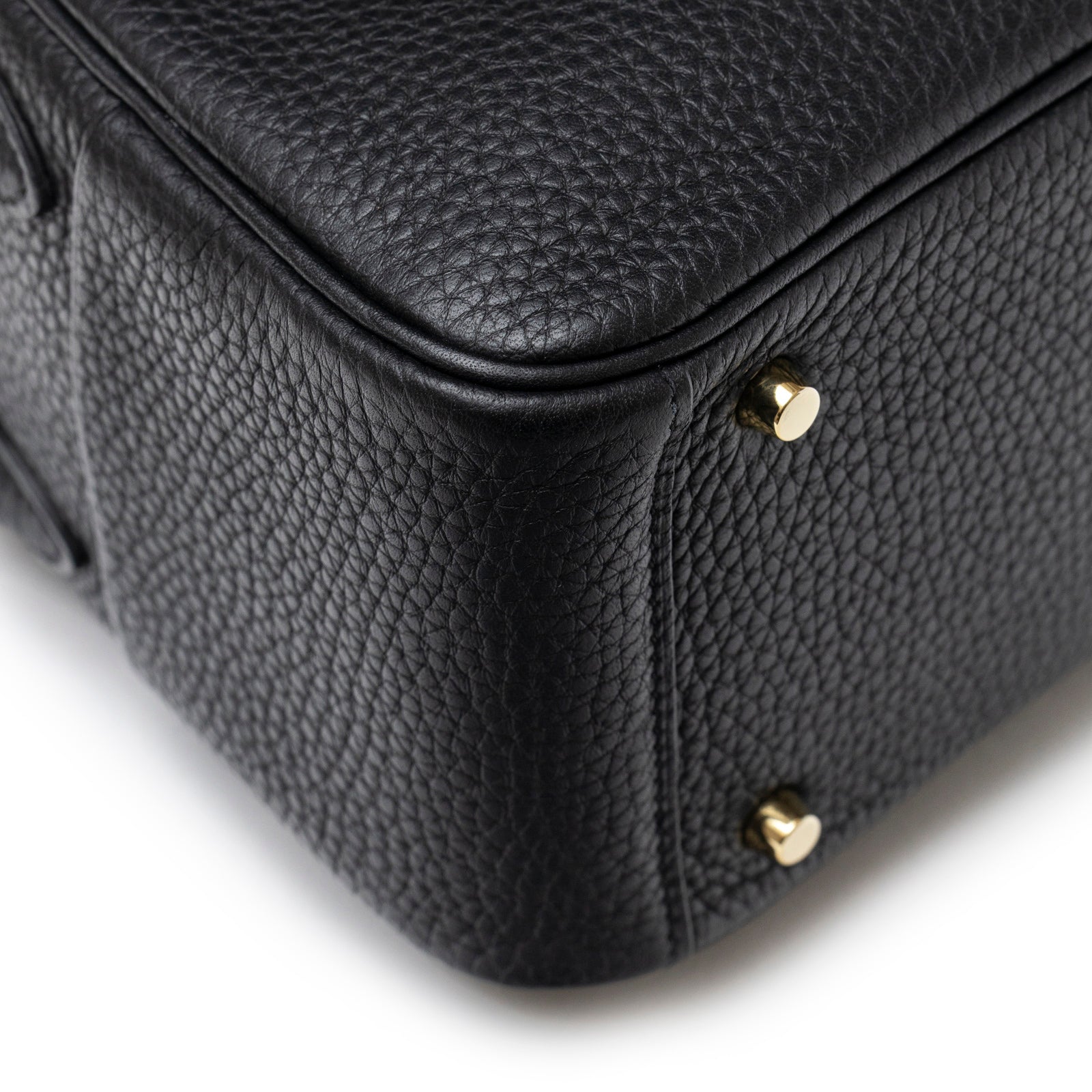 Close-up of Hermès Mini Lindy I Black Clemence Gold Hardware showing textured leather corner and protective feet