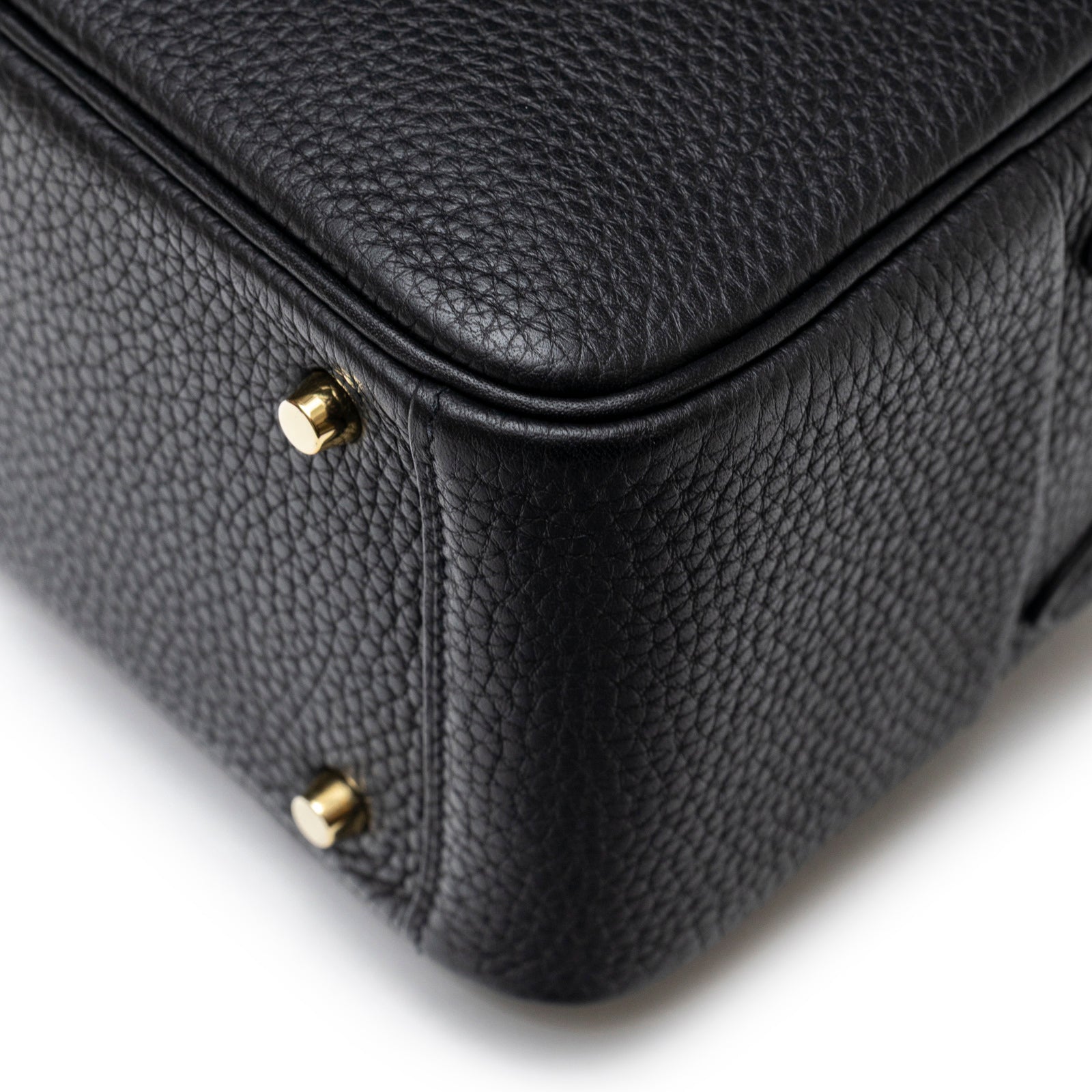 Close-up of bottom corner showing textured black Clemence leather and gold hardware on Hermès Mini Lindy I Black Clemence Gold Hardware
