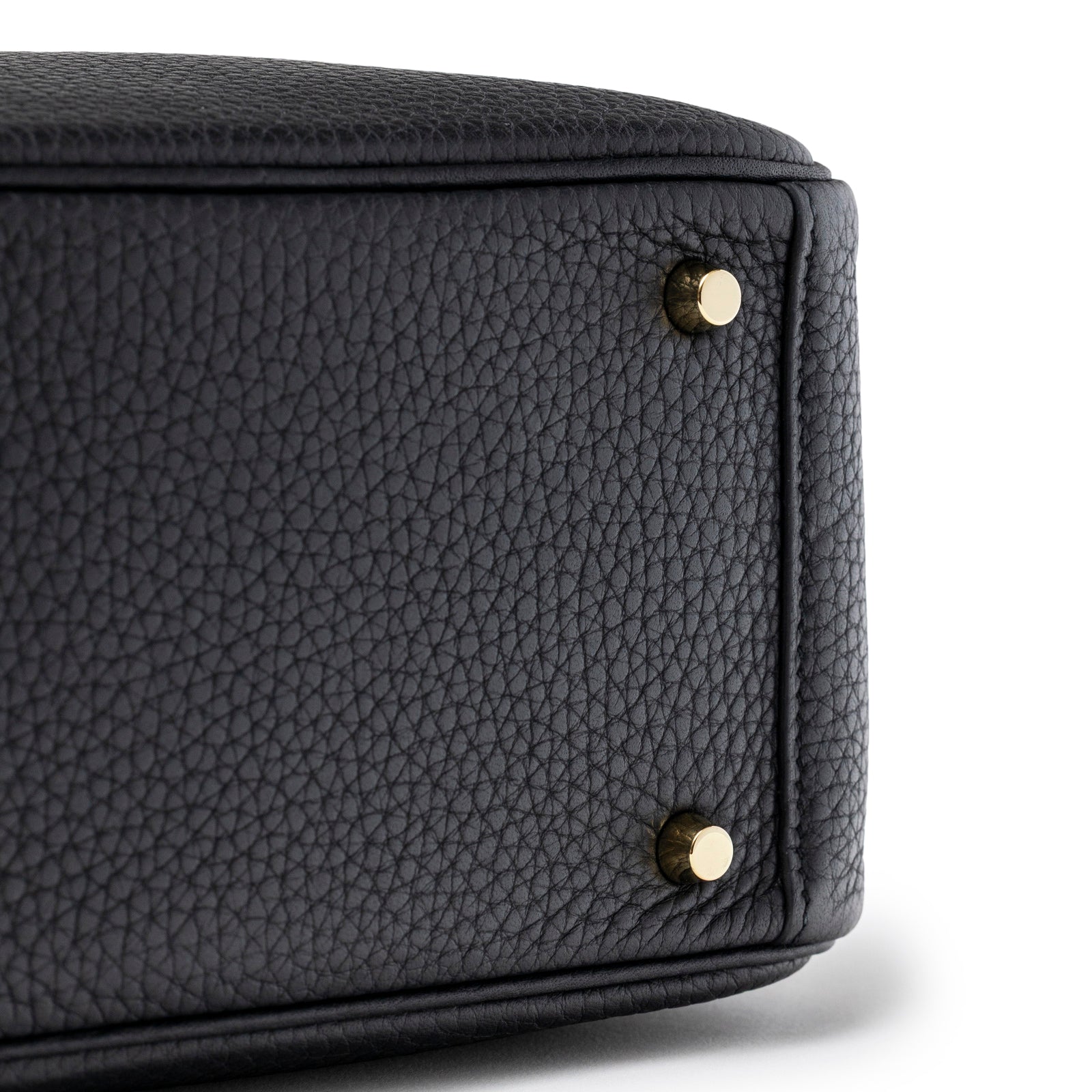 Close-up of the bottom corner of Hermès Mini Lindy I Black Clemence Gold Hardware showing textured leather and gold studs