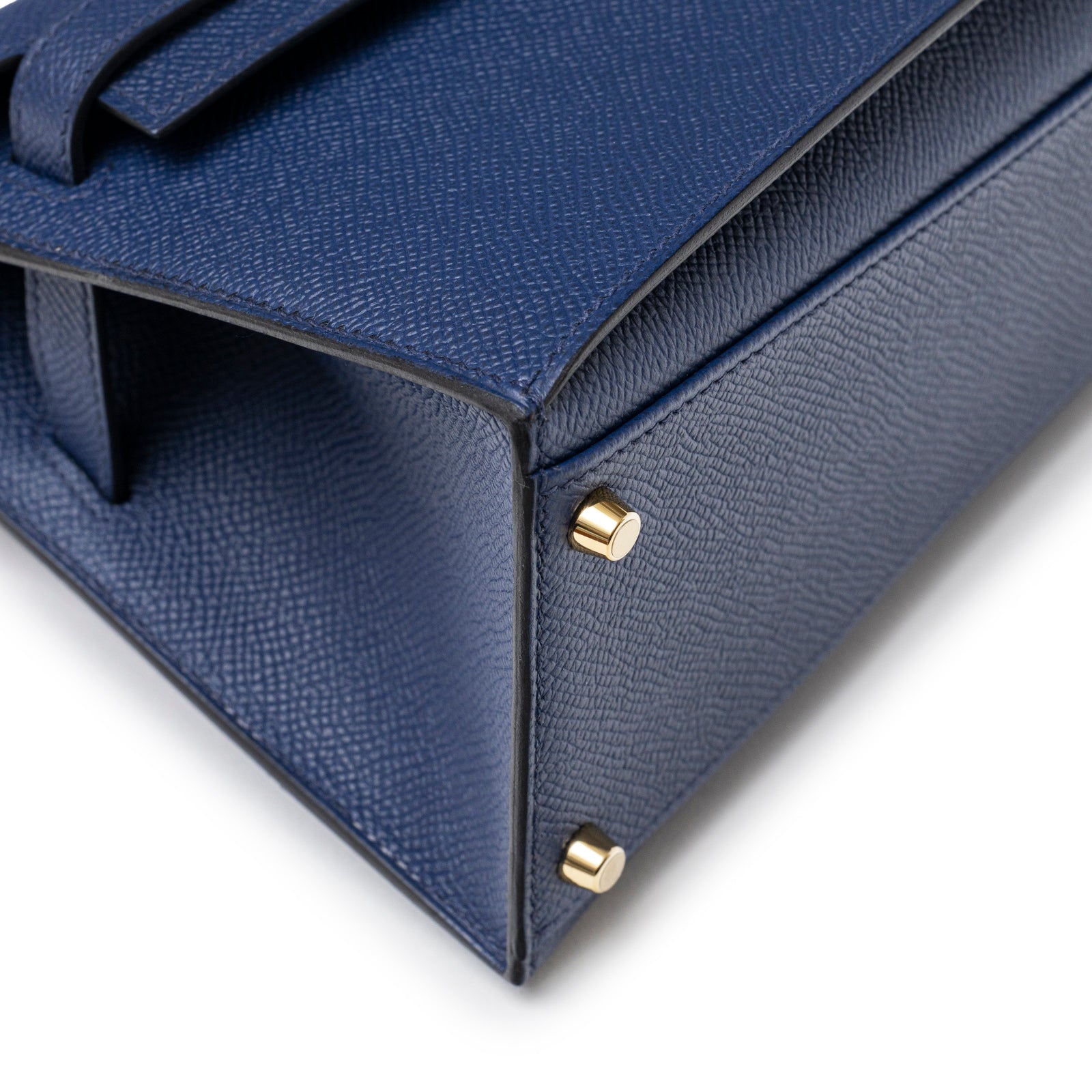 Close-up angled shot of Hermès Kelly Desordre 20 Sellier Blue Saphir Epsom Gold Hardware bag corner and feet details