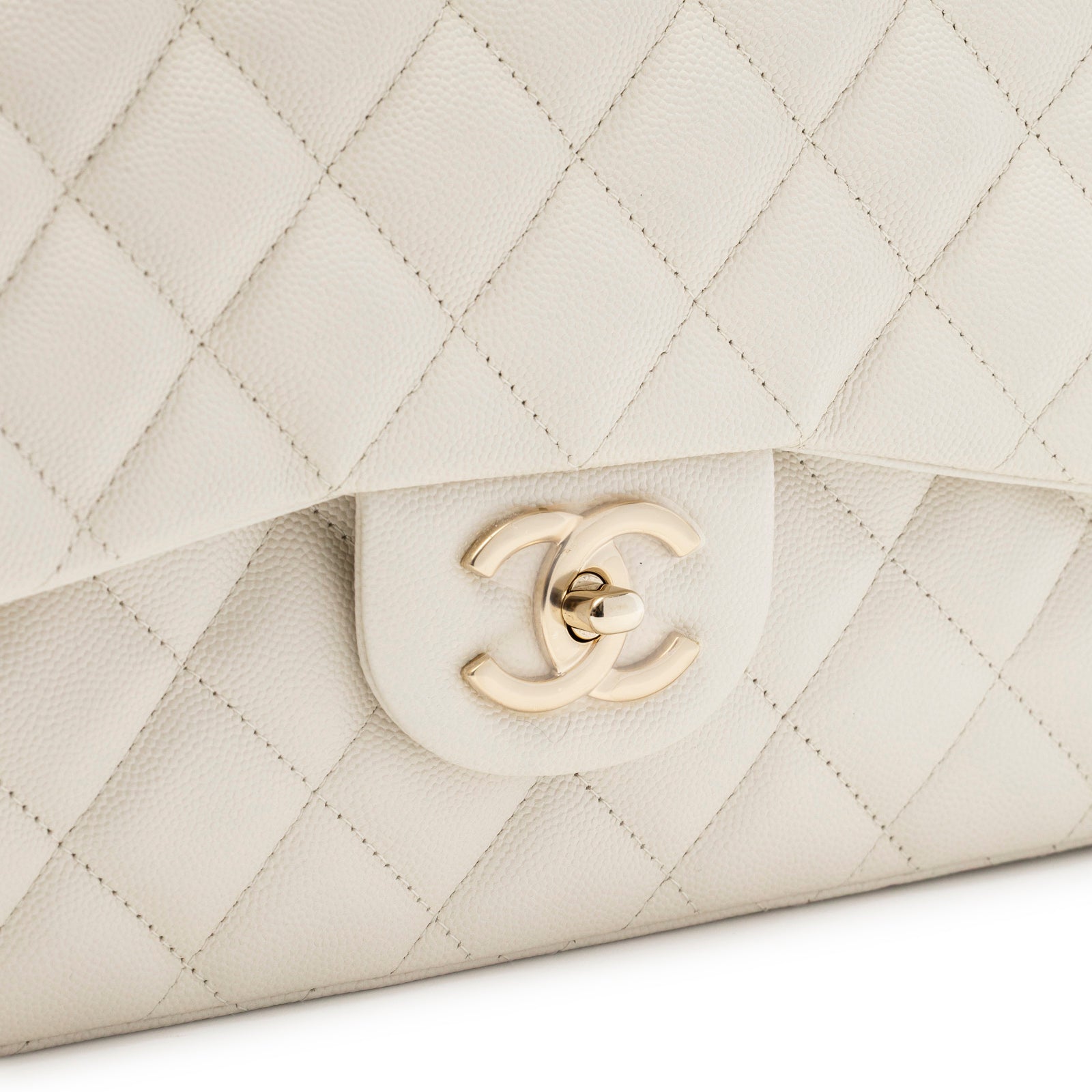 Close-up front view of Chanel Classic Flap Maxi Caviar White Gold Hardware showing quilted leather and logo clasp