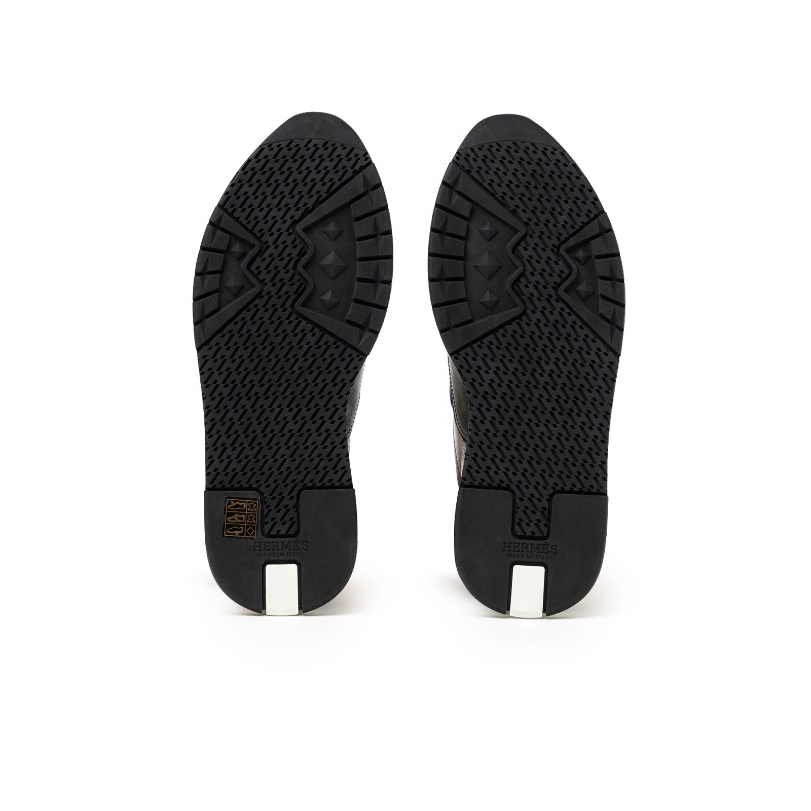 Bottom view of Hermès Men's Trail Sneaker Black showing detailed black rubber tread and heel design