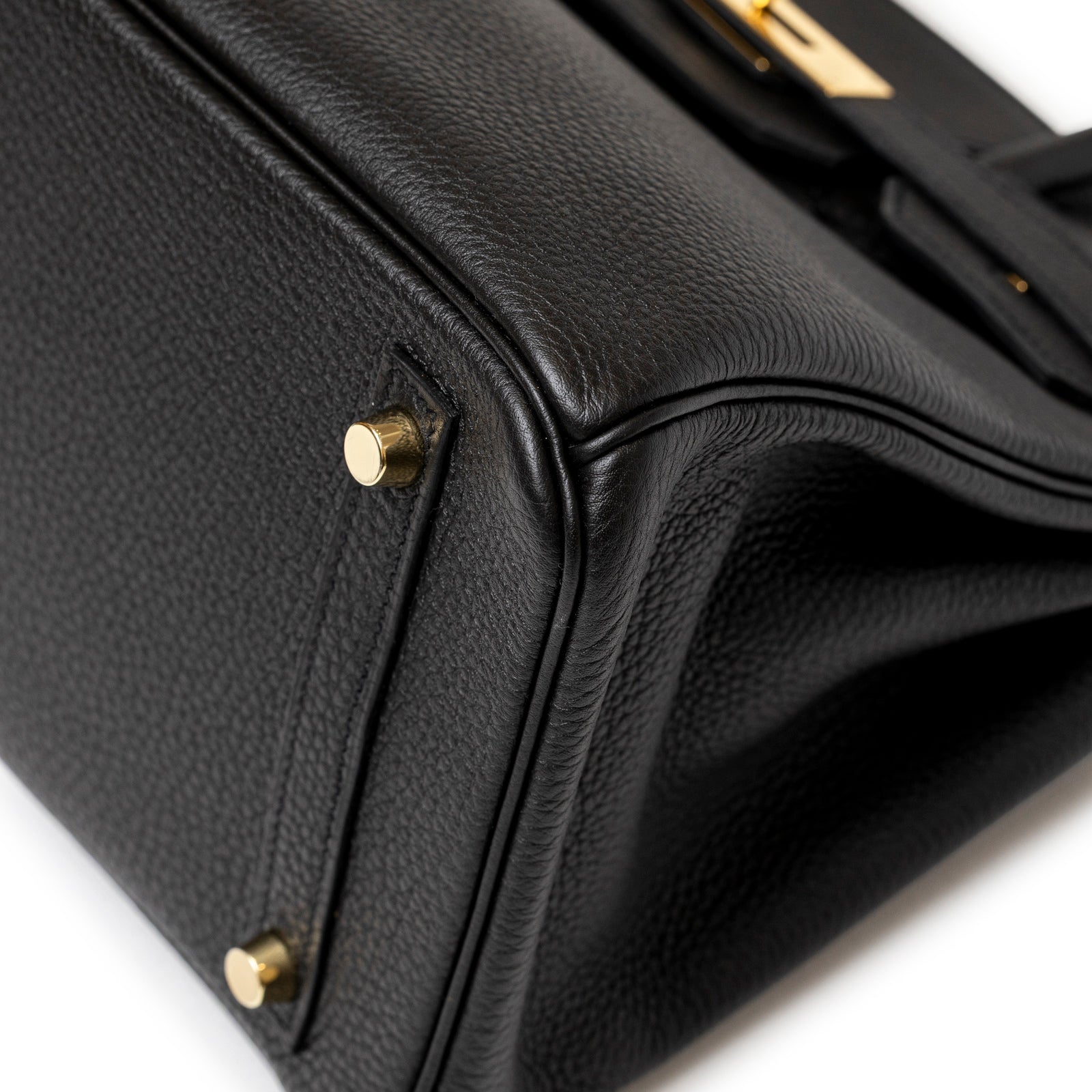 Hermès Birkin 30 Black Togo Gold Hardware showcasing textured leather corner and polished gold feet detail up close
