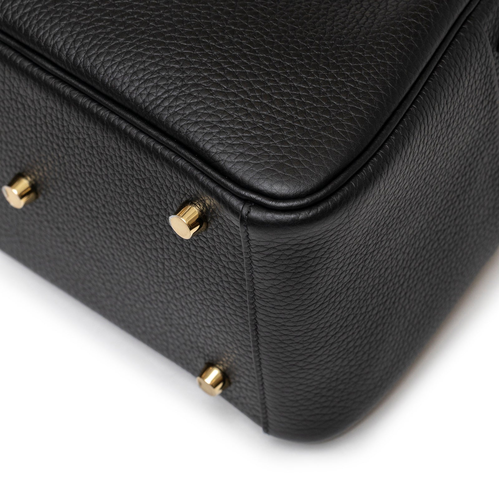 Close-up of textured black leather corner with gold hardware feet on Hermès Lindy 26 Black Clemence Gold Hardware bag