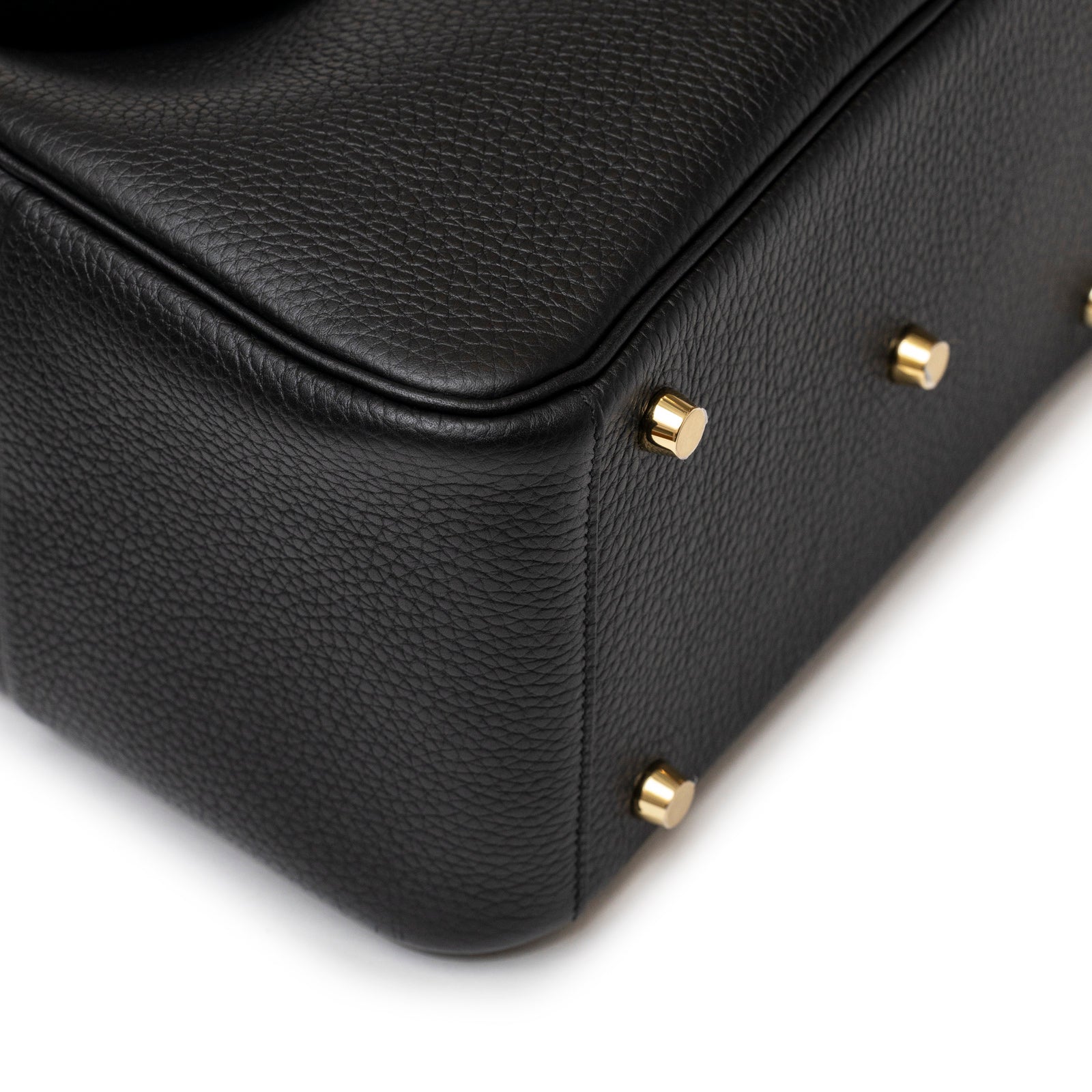 Close-up of the textured black leather bottom with gold studs on the Hermès Lindy 26 Black Clemence Gold Hardware handbag