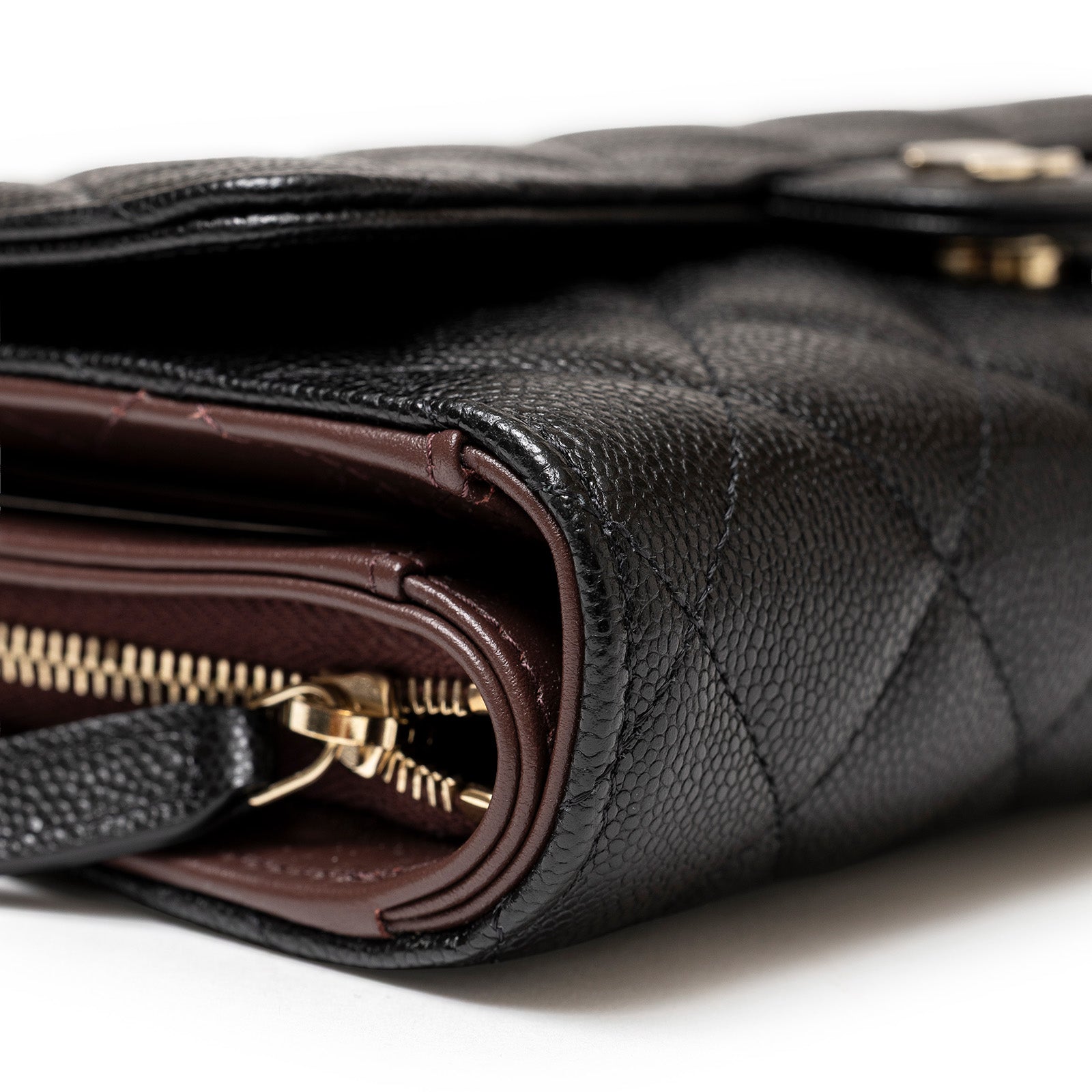 Close-up side view of Chanel 24S Classic Clutch On Chain Caviar Black Gold Hardware showing zipper and textured leather details
