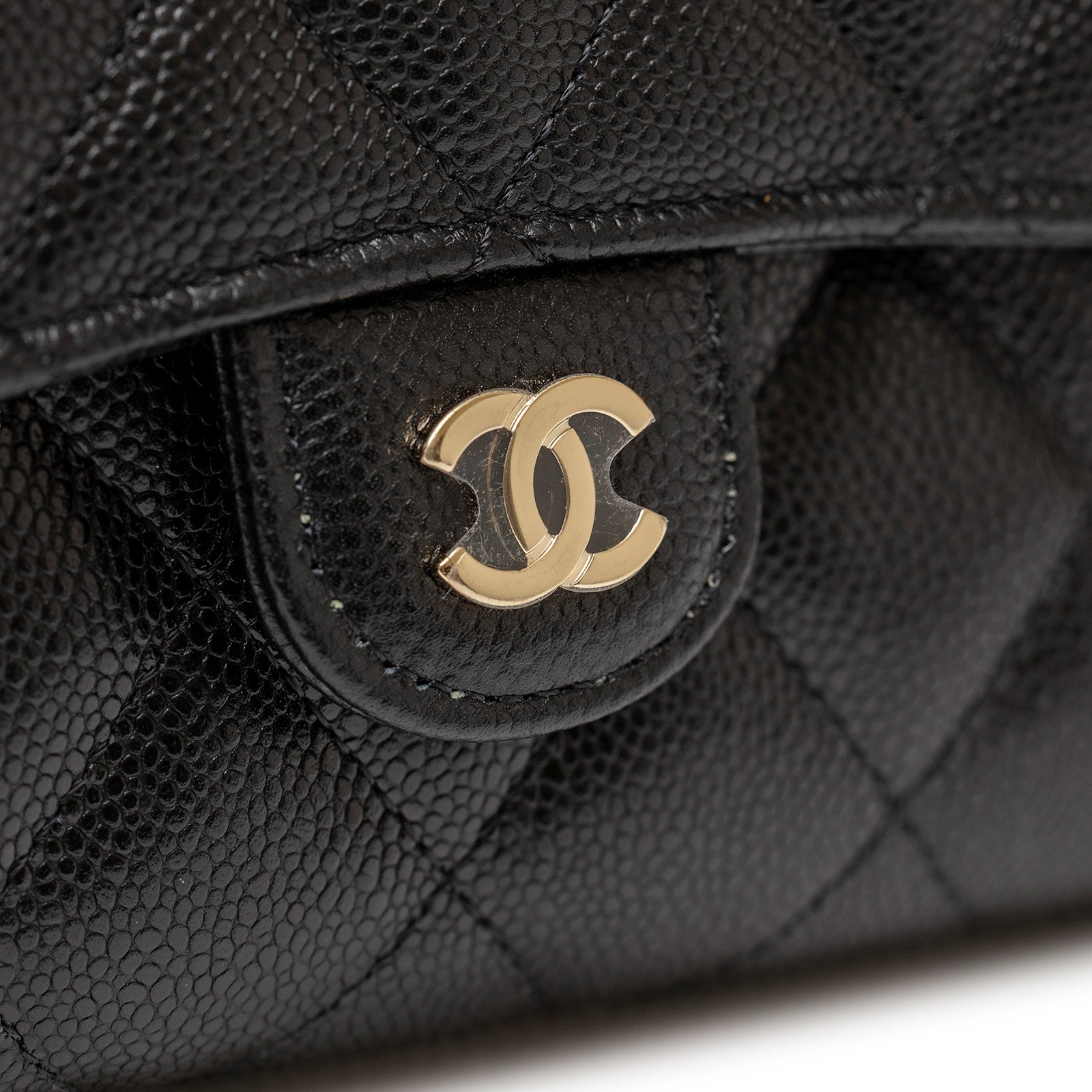Close-up of gold hardware and textured leather detail on Chanel 24S Classic Clutch On Chain Caviar Black Gold Hardware