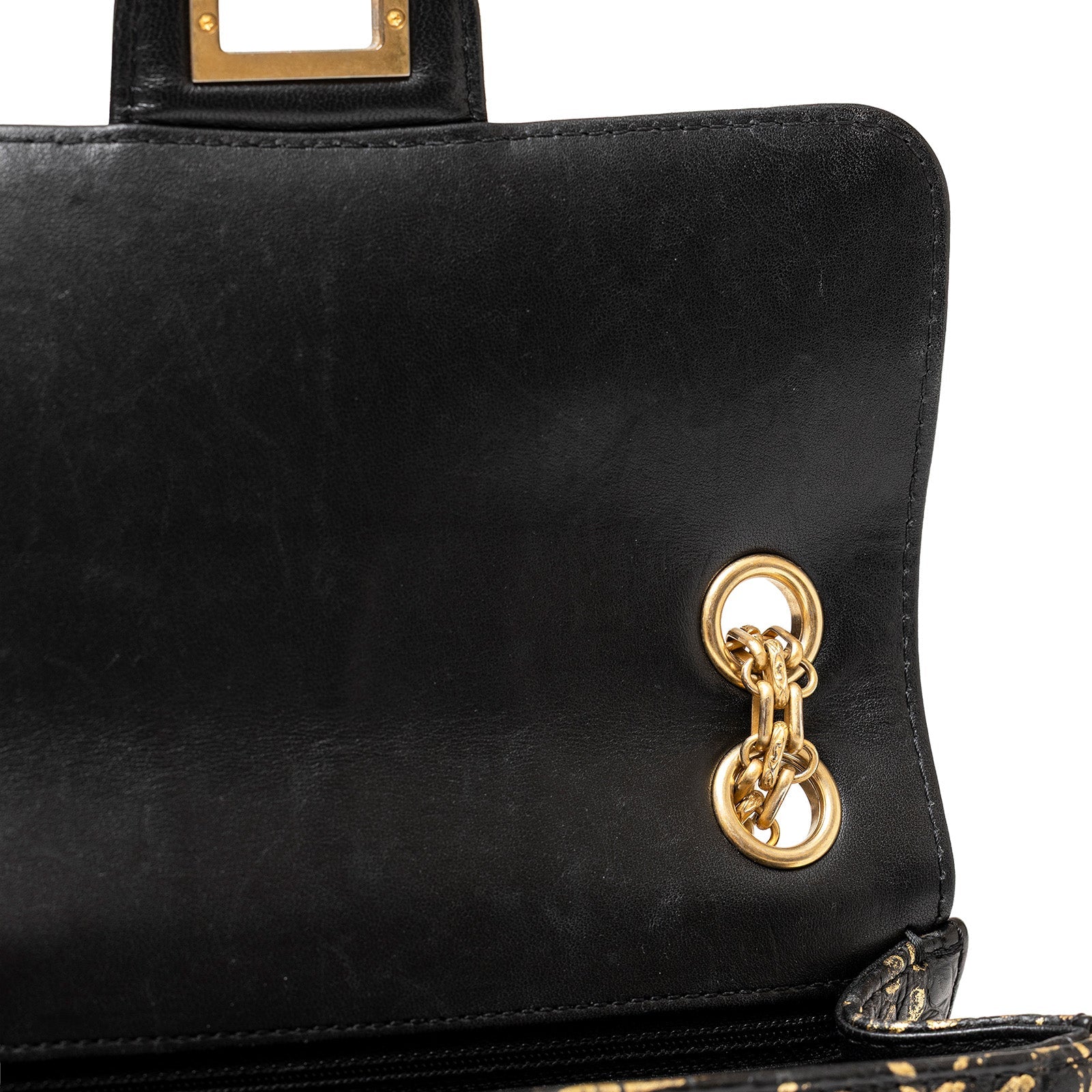 Close-up interior view of Chanel 2.55 Reissue 224 Flap Bag Black and Gold Graffiti Crocodile Embossed Calfskin Gold Hardware showing gold chain grommets