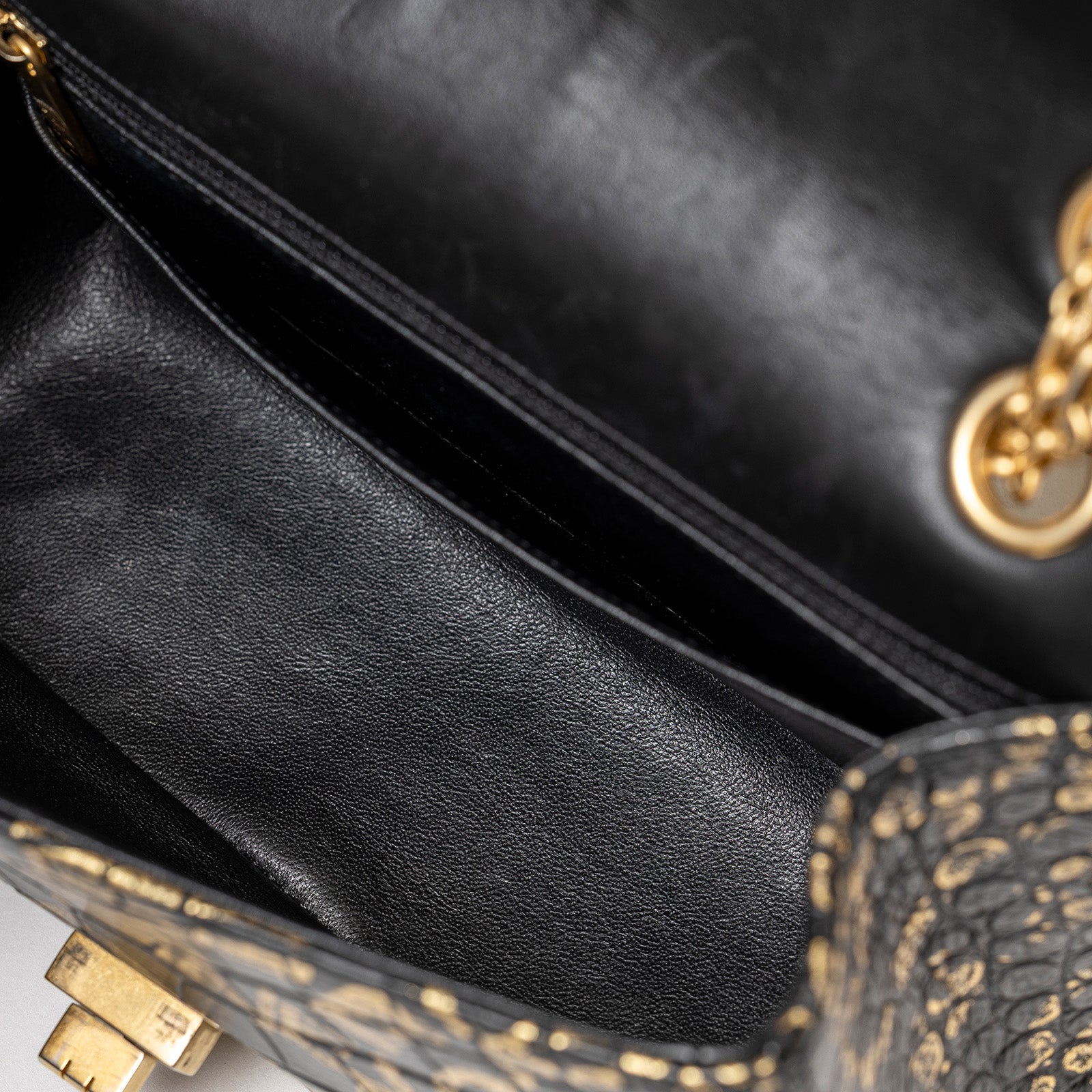 Close-up interior view of Chanel 2.55 Reissue 224 Flap Bag Black and Gold Graffiti Crocodile Embossed Calfskin Gold Hardware showing smooth black lining and gold clasp details.