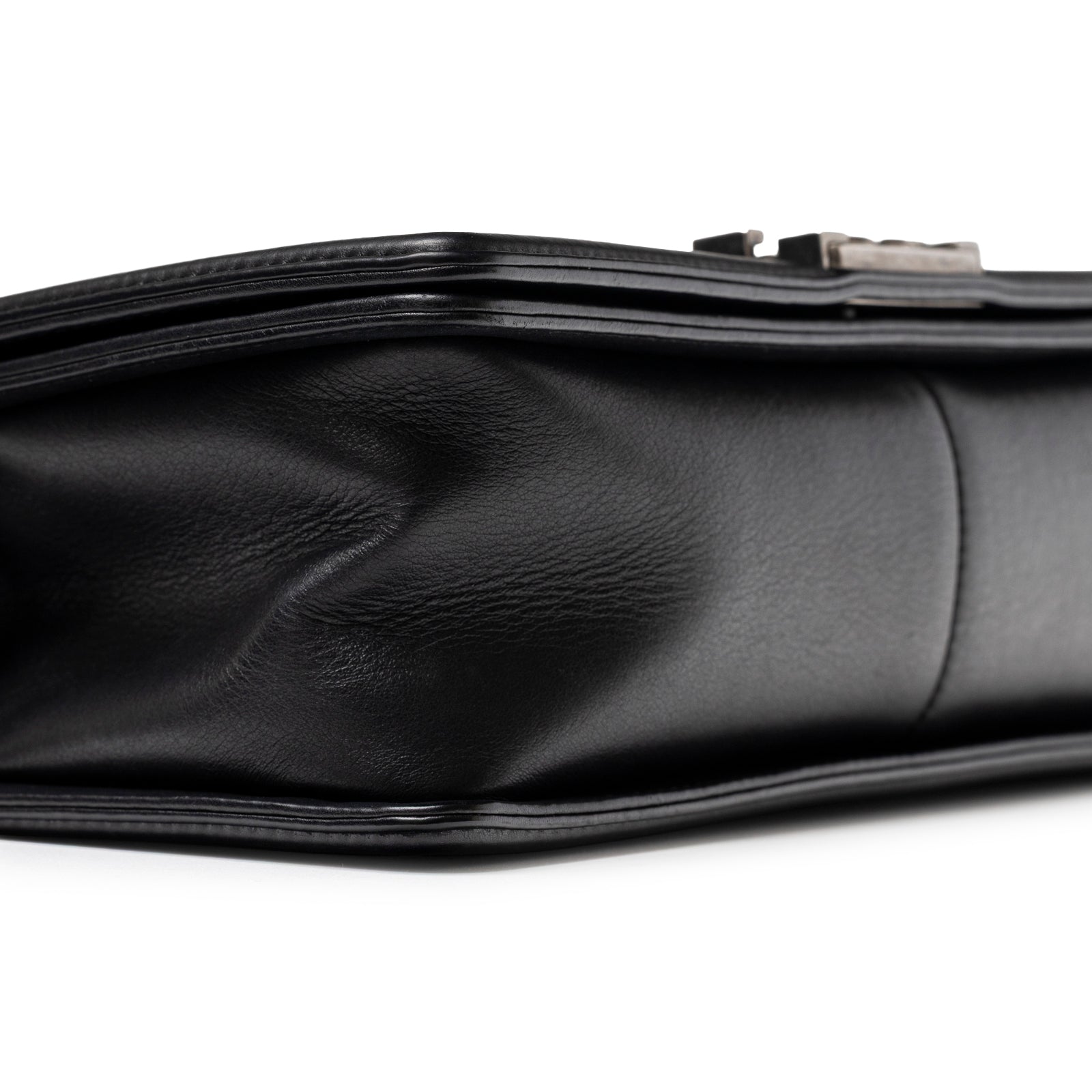 Close-up of bottom edge and side crease on Chanel Boy Bag Medium Black Lambskin Ruthenium Hardware