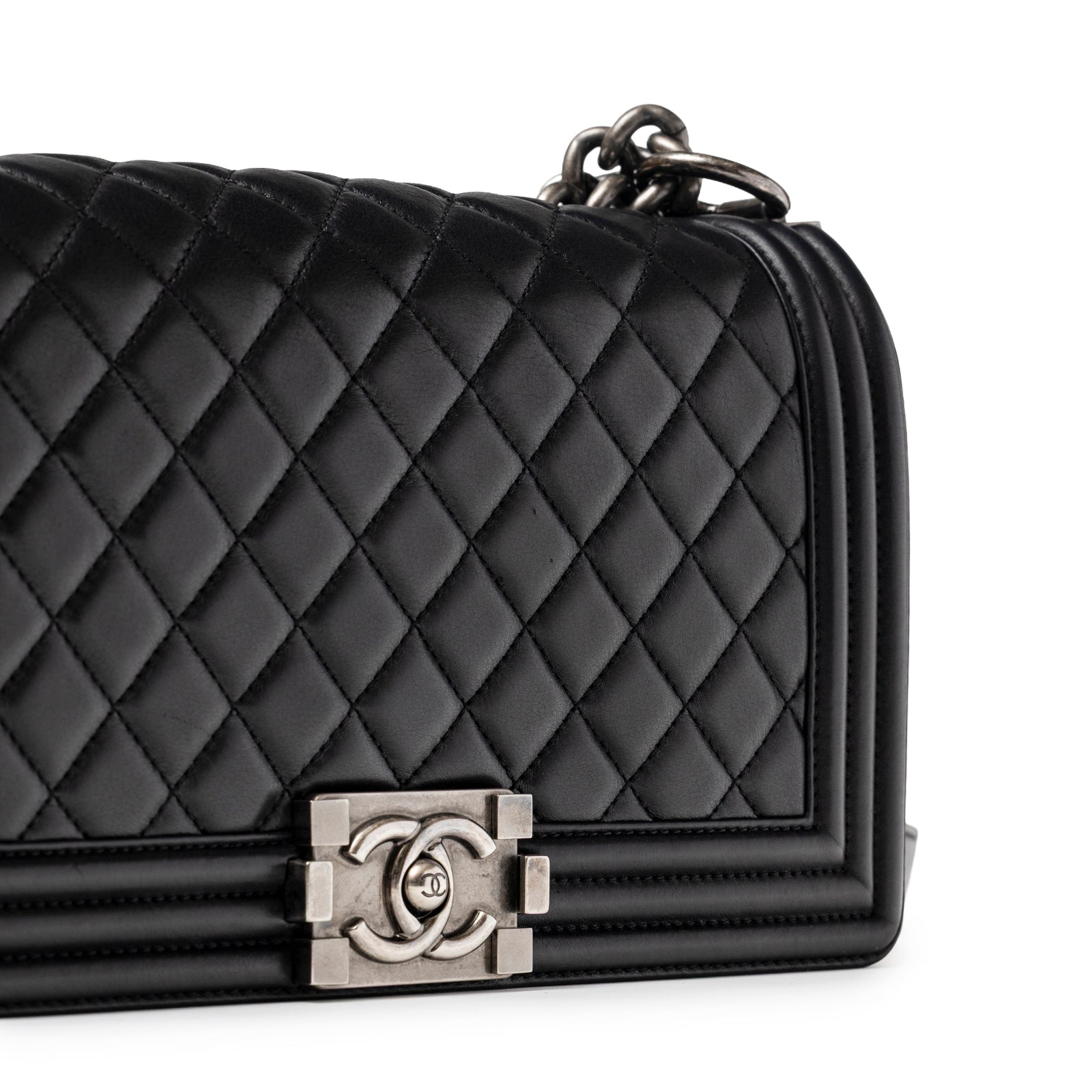 Close-up of front flap and ruthenium clasp on Chanel Boy Bag Medium Black Lambskin Ruthenium Hardware