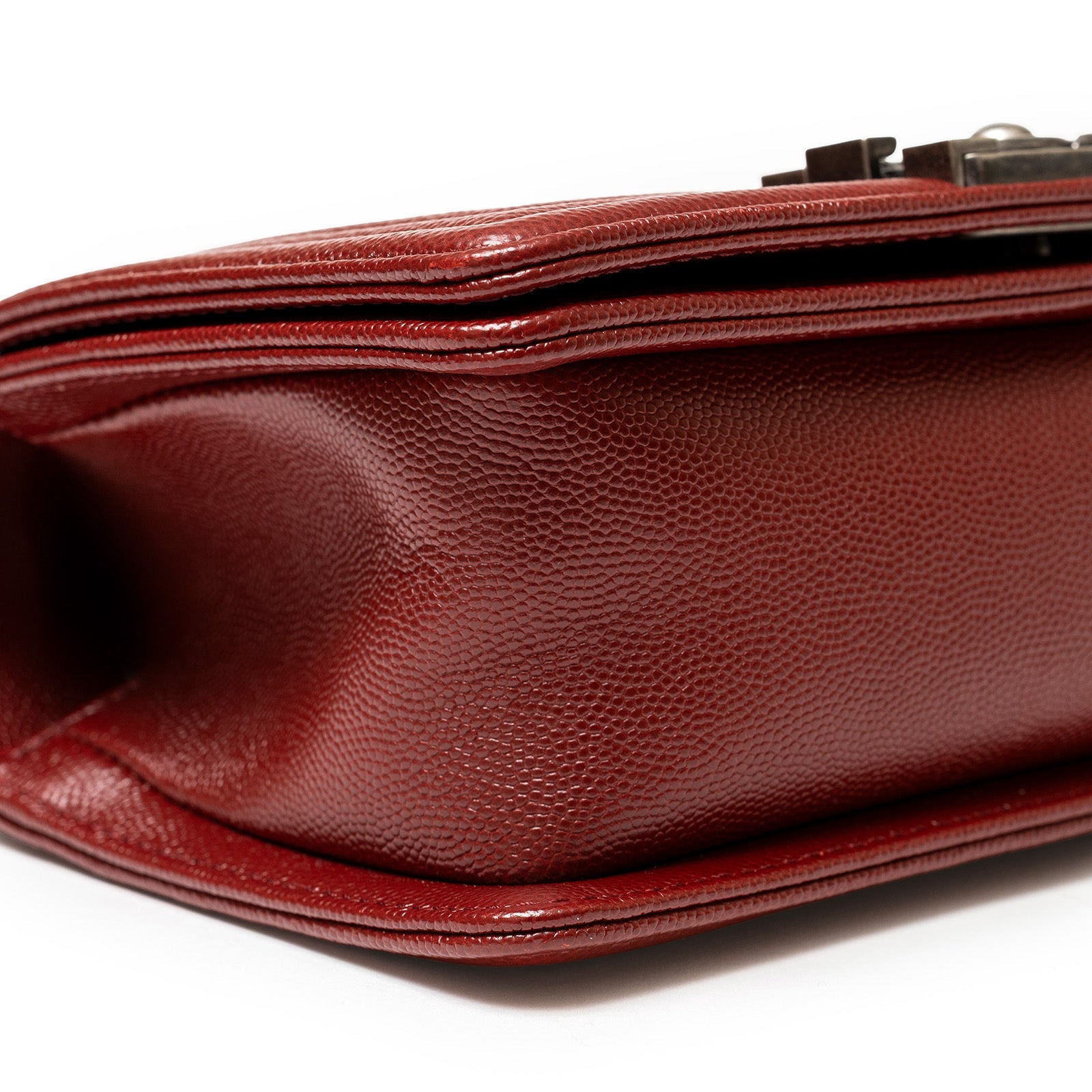 Bottom close-up of Chanel Small Boy Flap Bag Chevron Burgundy Caviar Palladium Hardware showing textured leather and edges